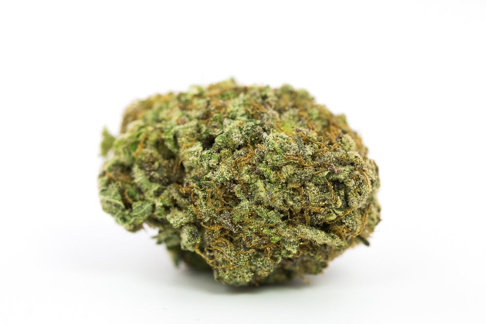 Detailed view of Green Crack flower showcasing frosty trichomes and premium bud structure