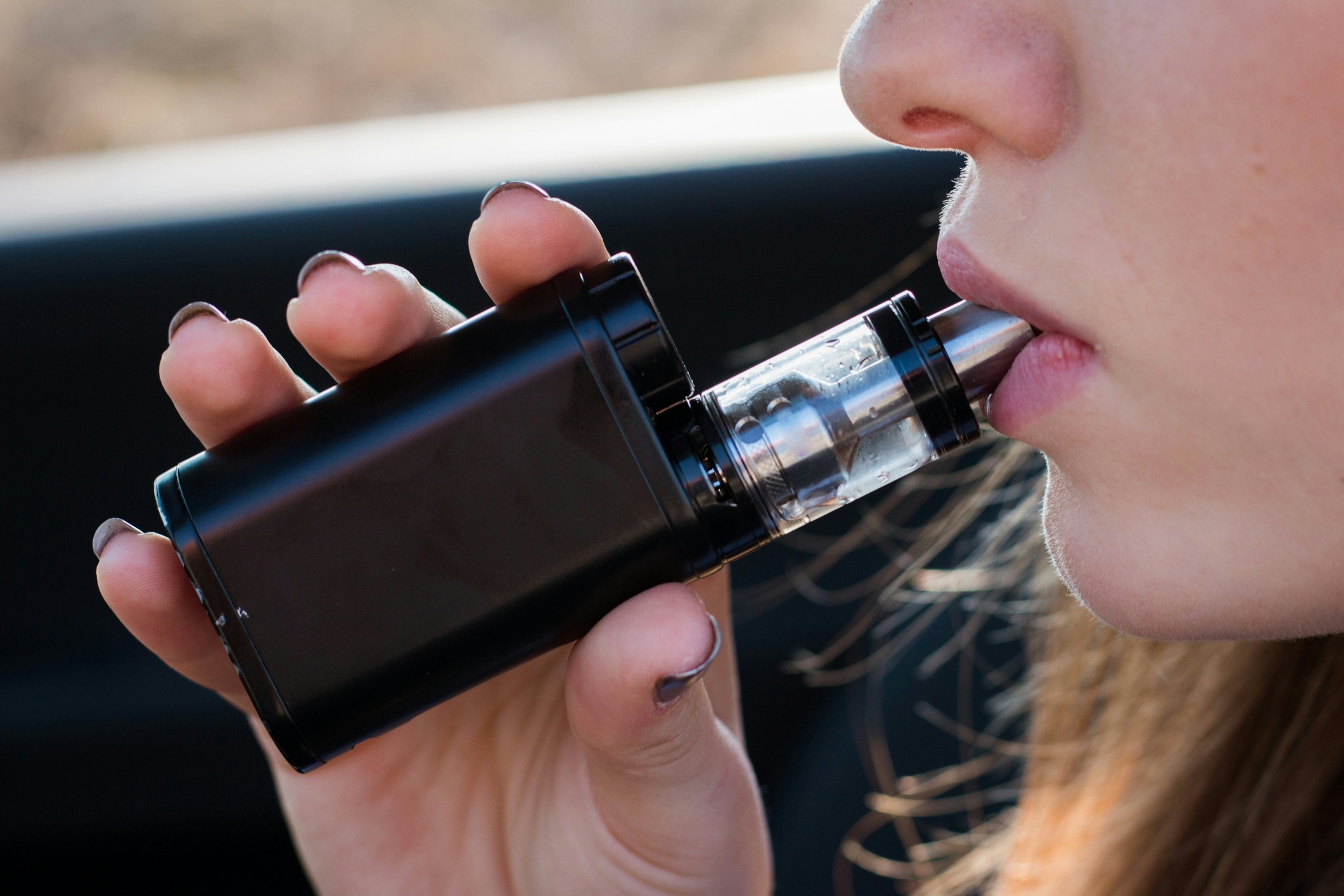 Woman Vaping behind the wheel