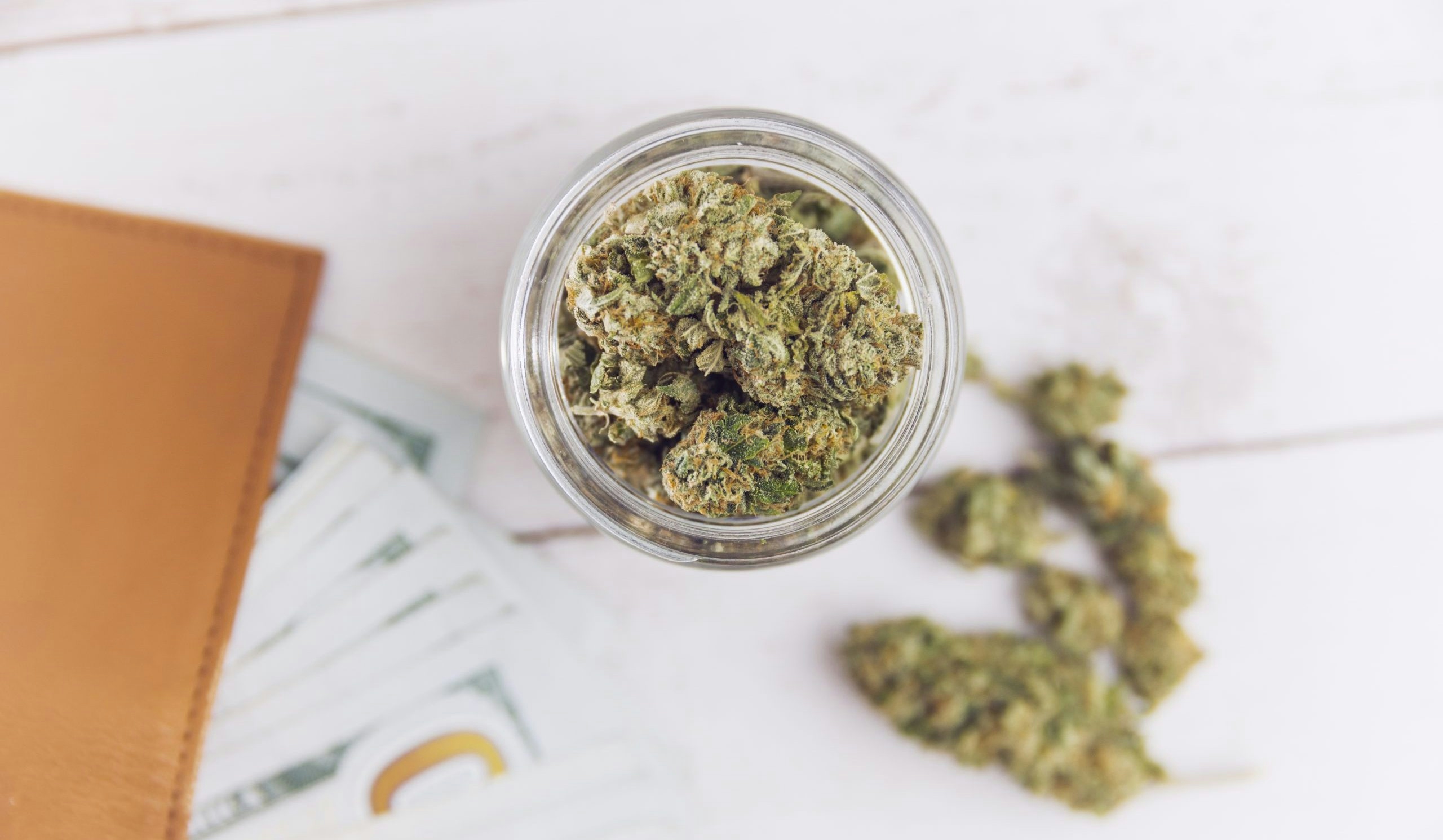 cannabis flower with wallet of money
