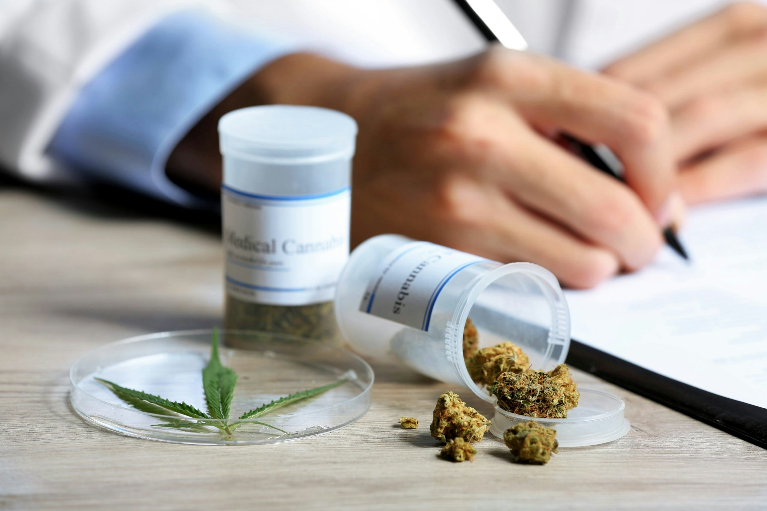 Doctor writing on prescription blank and bottle with medical can
