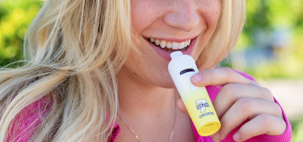 Blonde woman holding a vape
