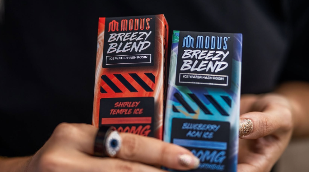 Hand holding two Modus Breezy Blend boxes