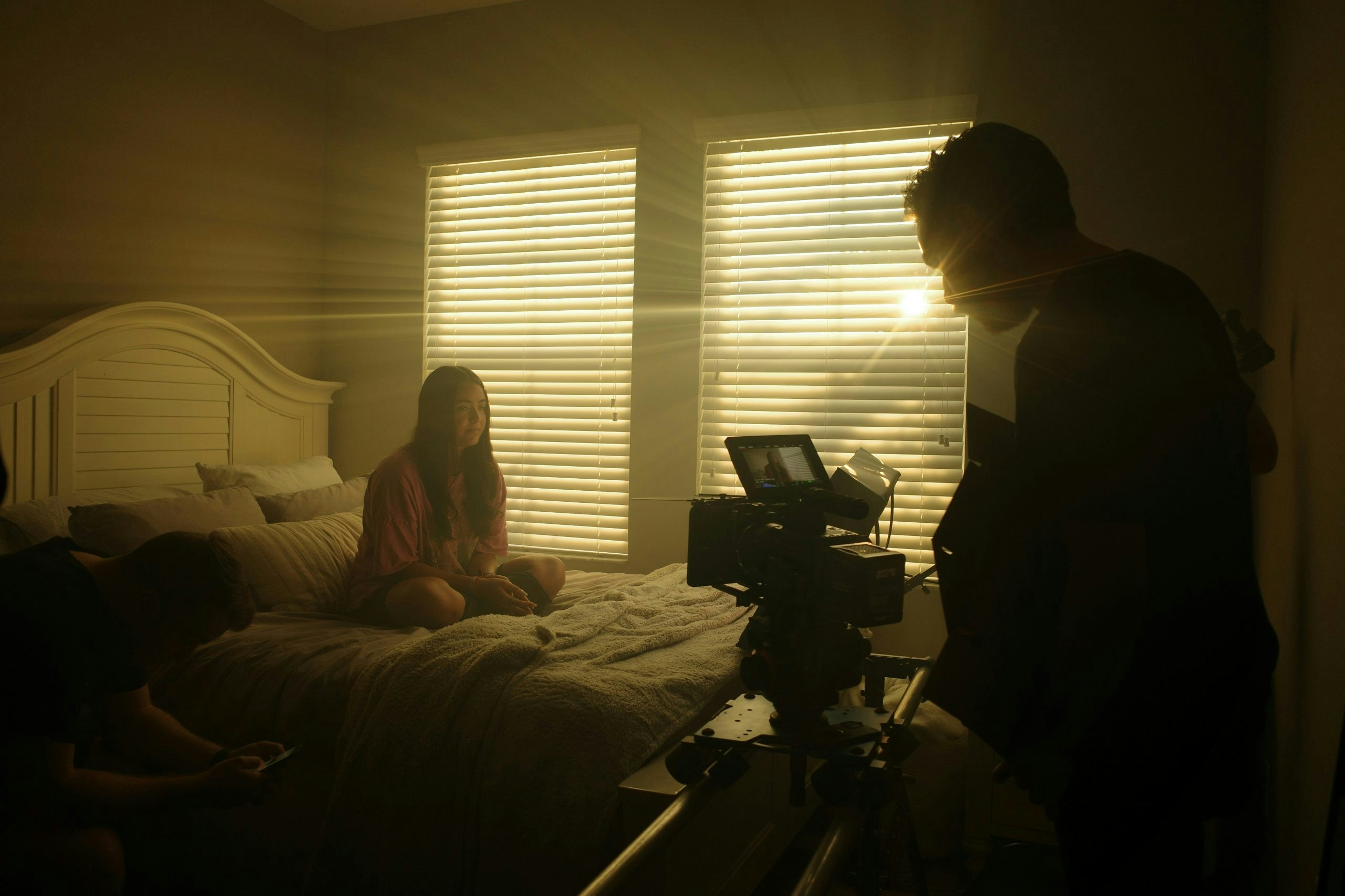 Man holding a camera directing and filming a girl