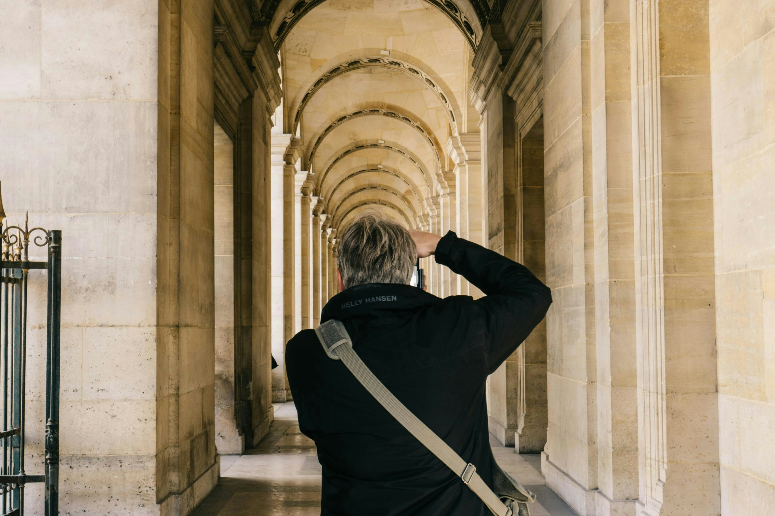 Man in black long sleeve jacket taking photo of building