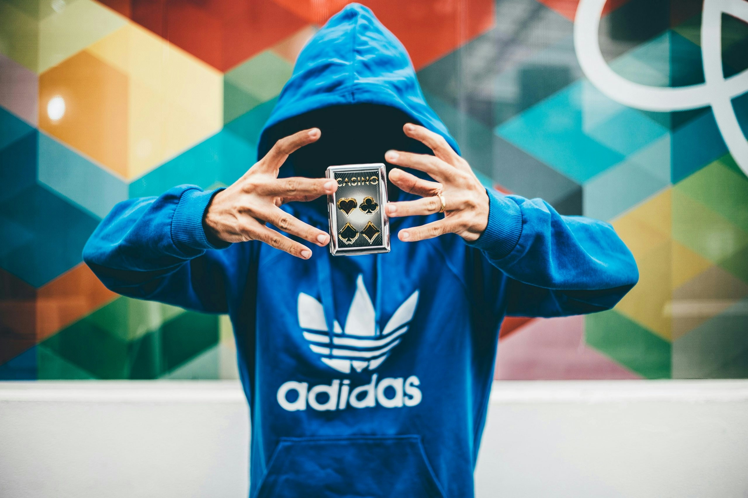 Man in blue Adidas hoodie doing magic trick