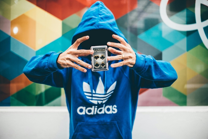 Man in blue Adidas hoodie doing magic trick