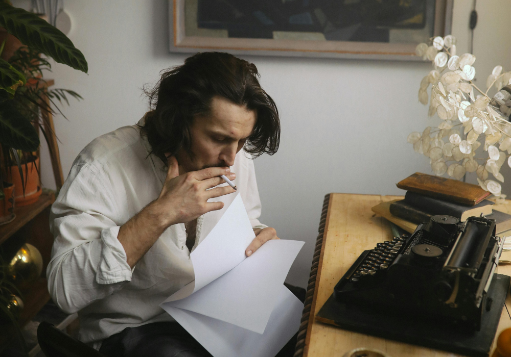 Man smoking while holding sheets of paper