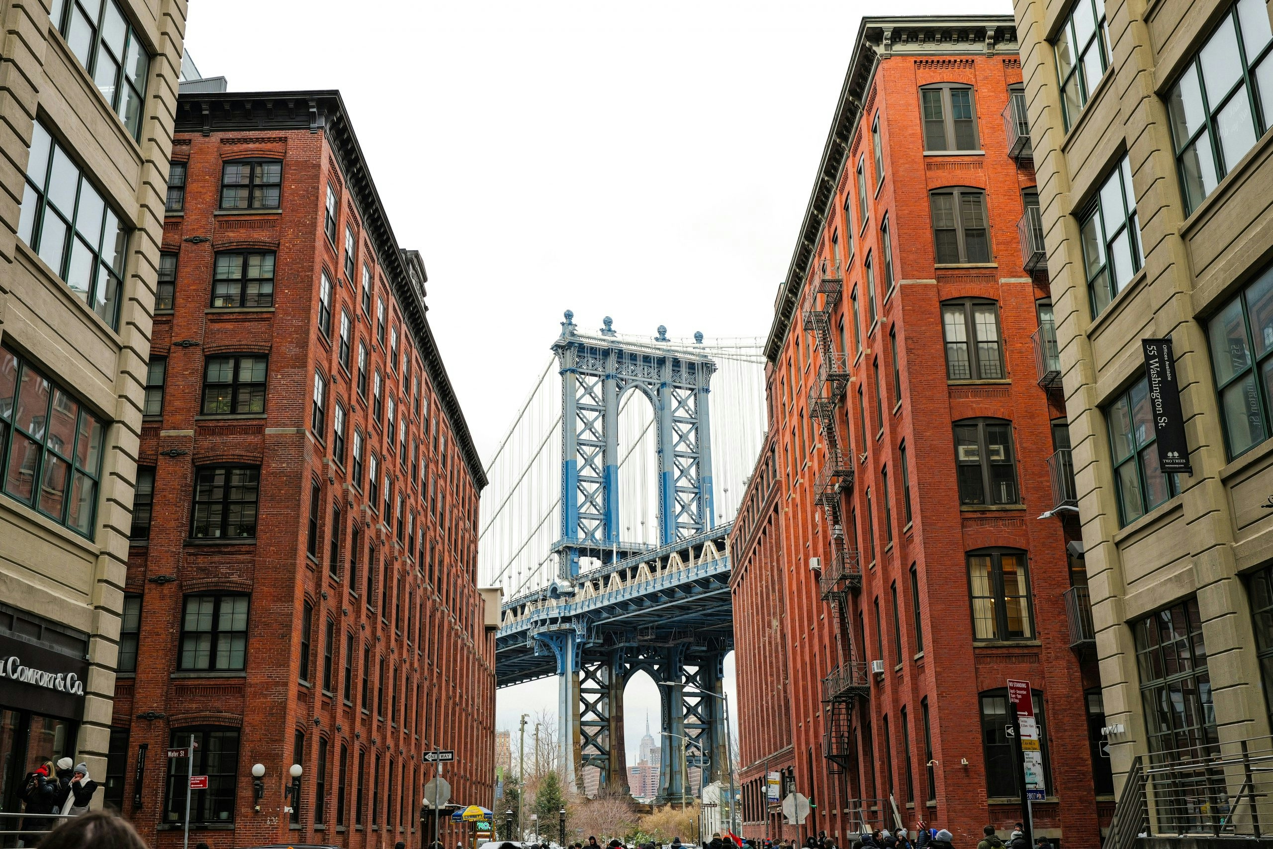 Group of people walking down a street next to tall buildings