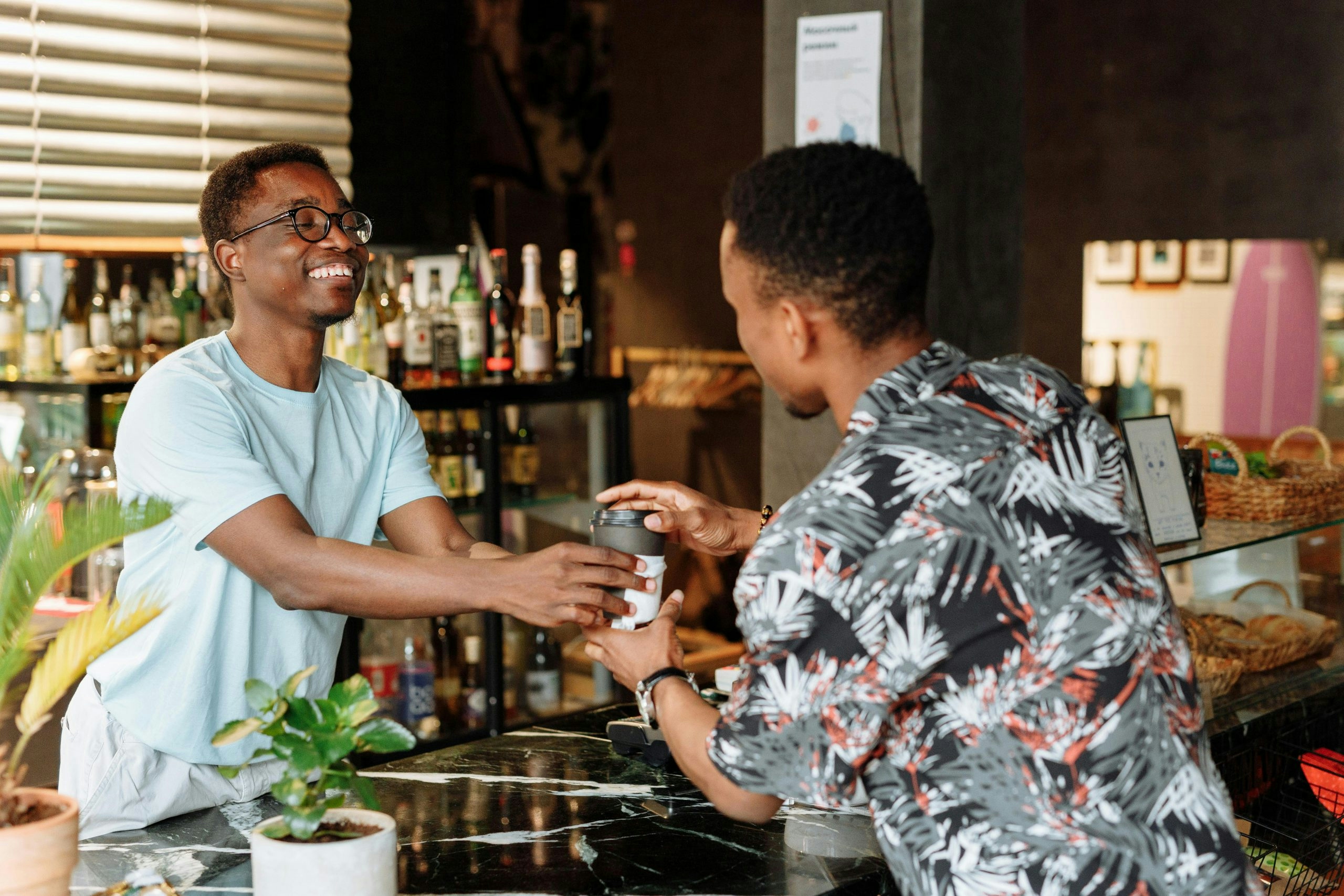 Man in White Shirt Holding a Drink in a Paper Cup