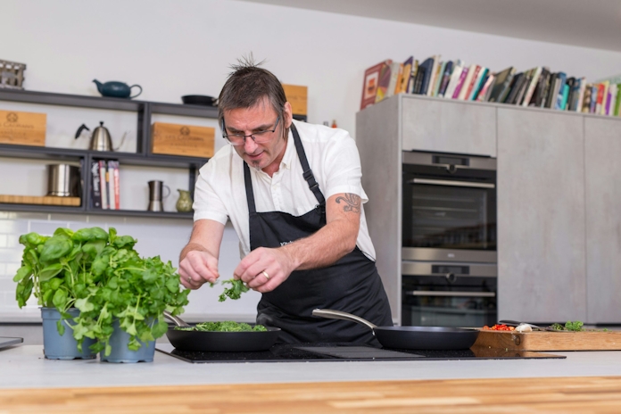 man in white button up shirt holding green vegetable on black ceramic plate