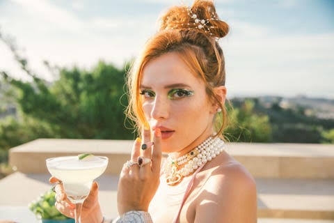 Bella Thorne posing in a photoshoot while holding a joint