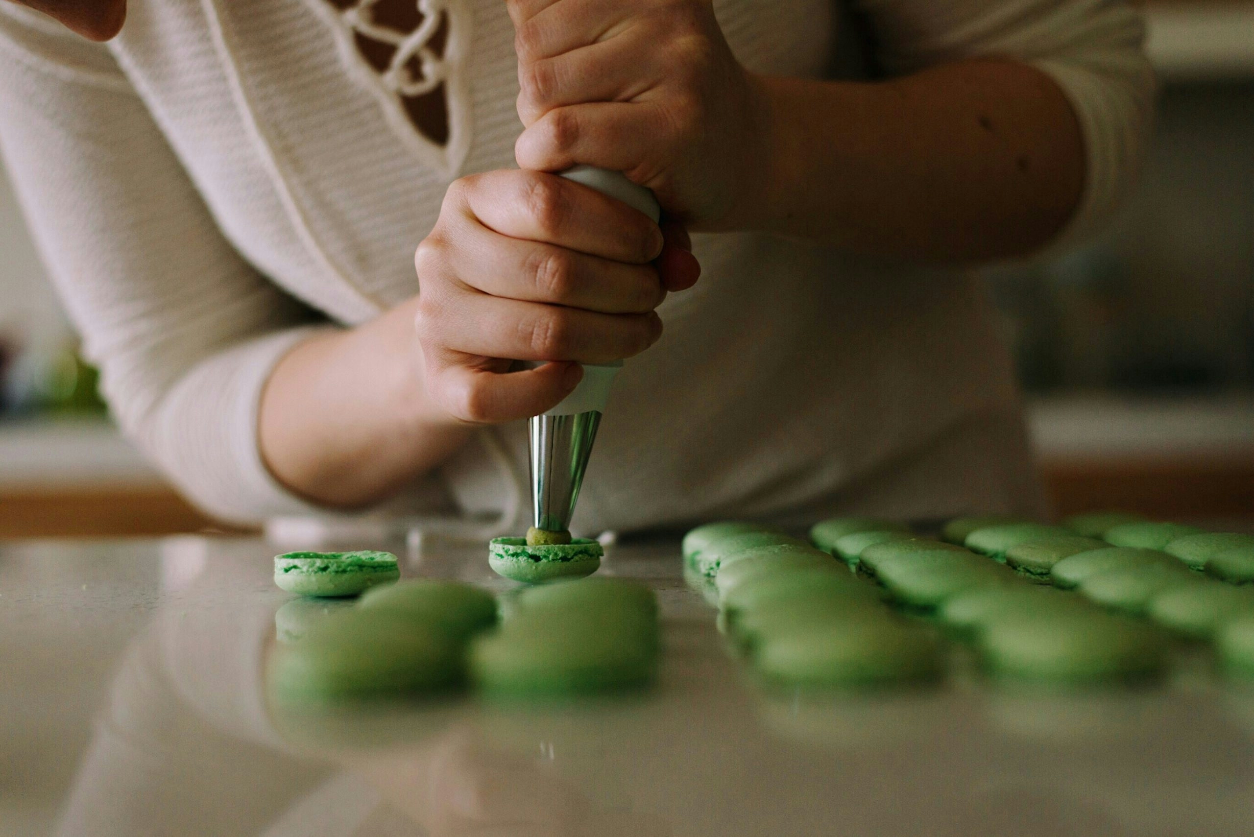Person preparing cannabis-infused macaroons in a kitchen