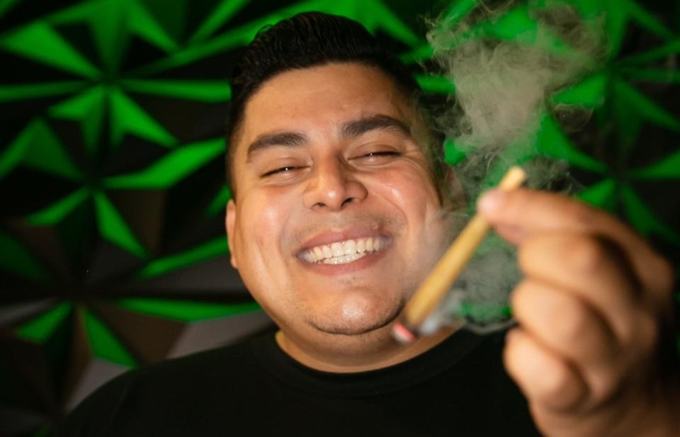 Dope As Yola posing while showing a joint in his hand.