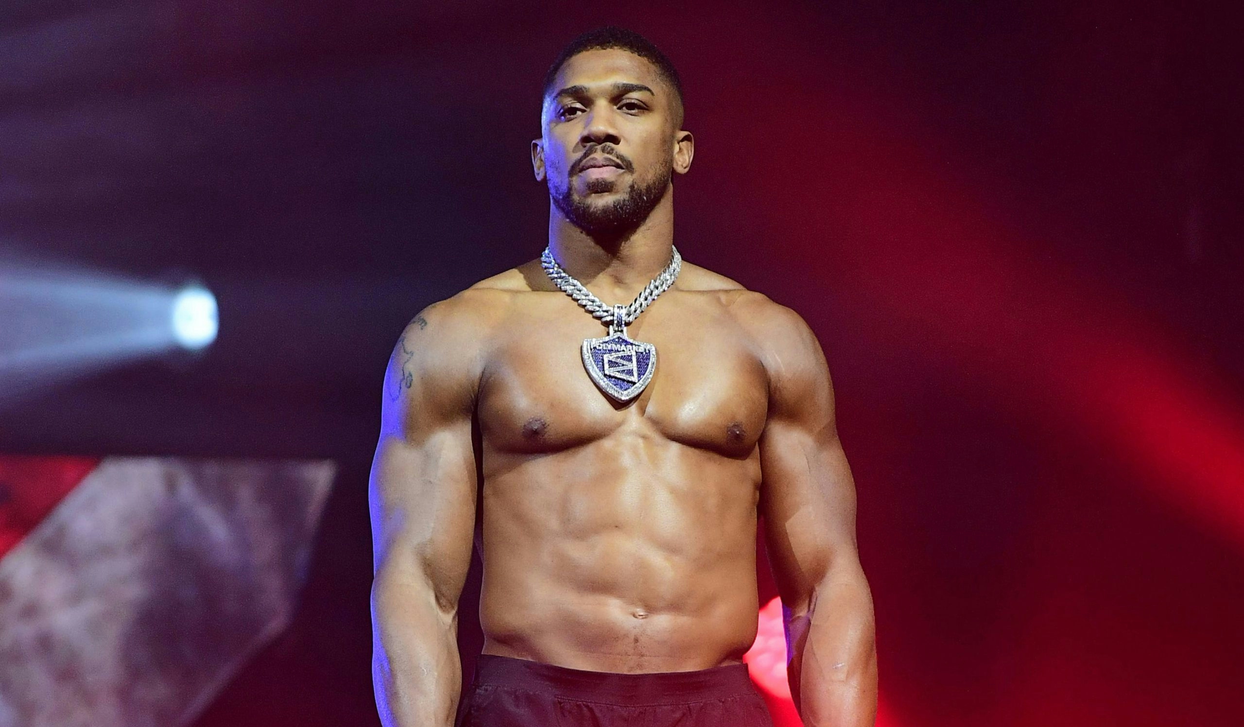Anthony Joshua in a professional boxing environment, standing in the ring during training or competition