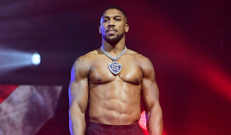 Anthony Joshua in a professional boxing environment, standing in the ring during training or competition