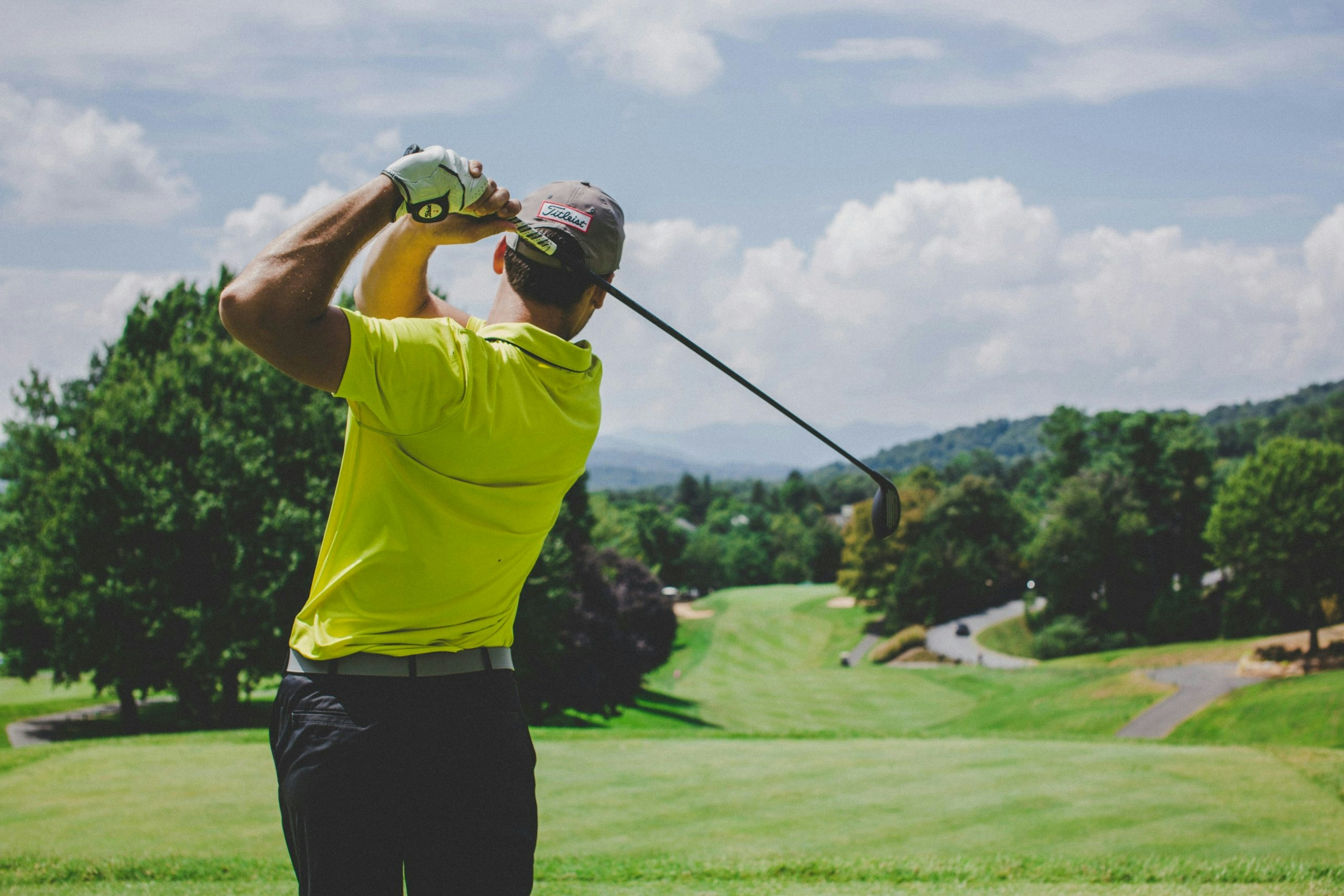 Golfer taking a tee shot on a sunny golf course