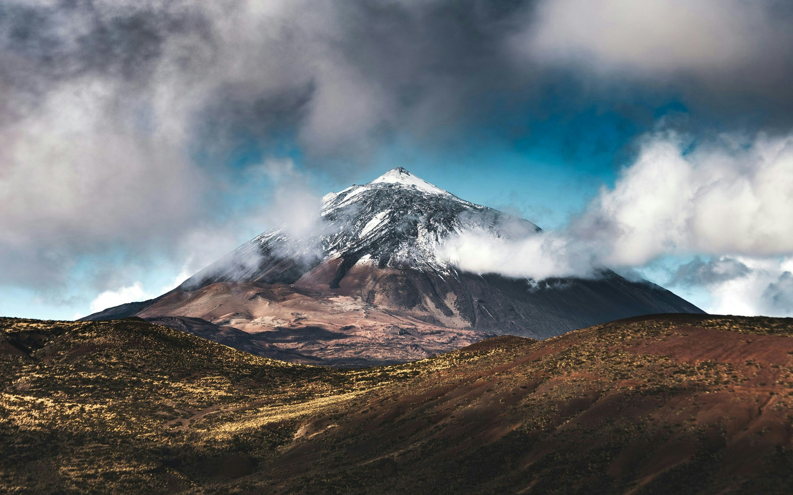 Mount Teide towering above Tenerife's volcanic landscape under a clear blue sky.