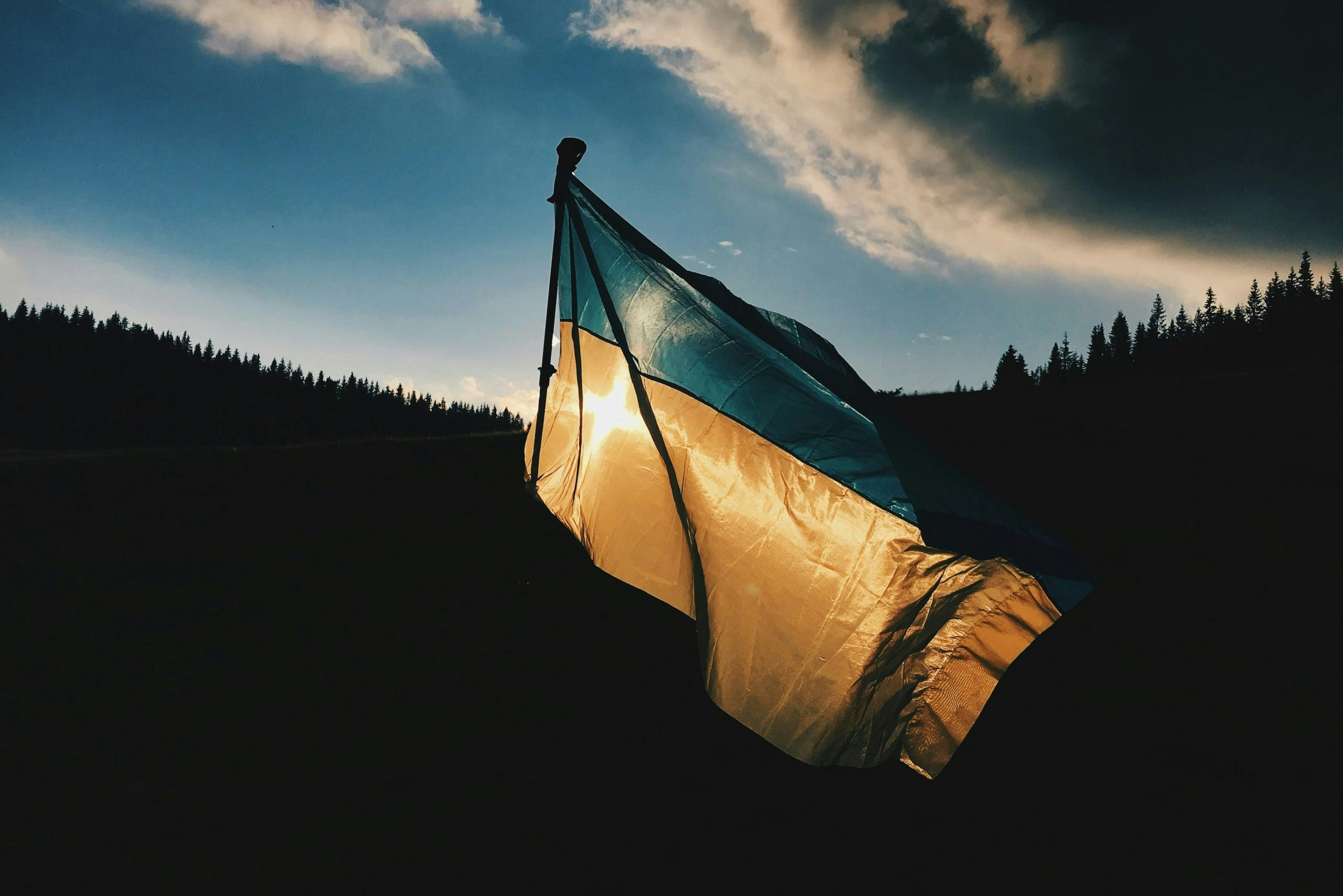 The Ukrainian flag waving against a clear blue sky