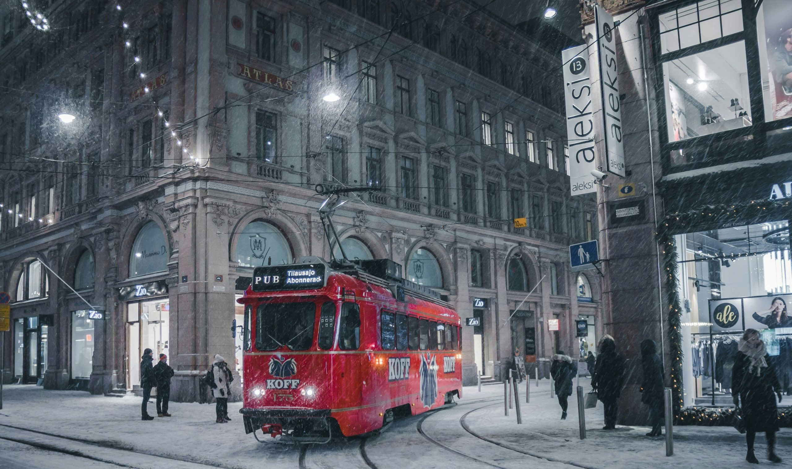 Snow-covered street in Helsinki with a modern tram traveling through the city center