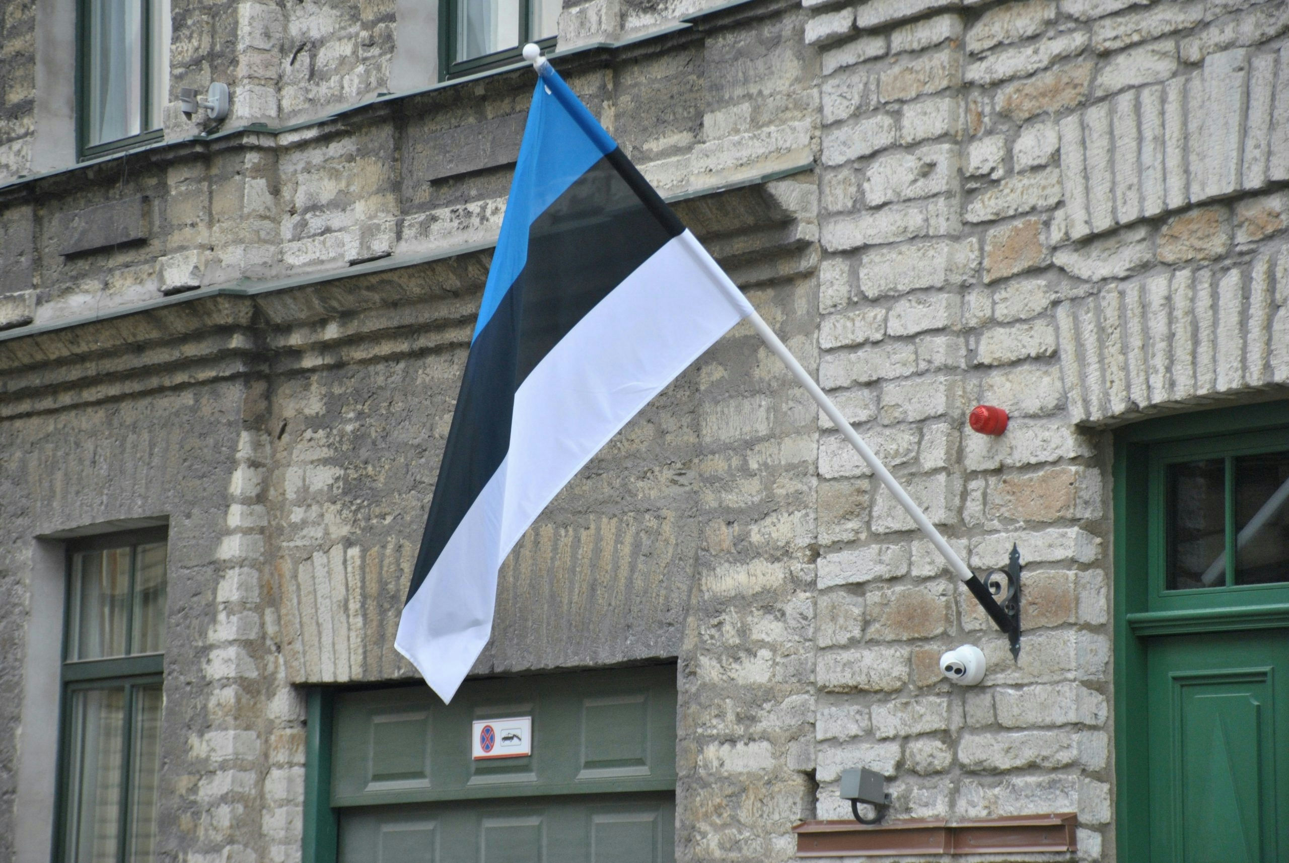 The Estonian flag waving in front of a historic building in Tallinn