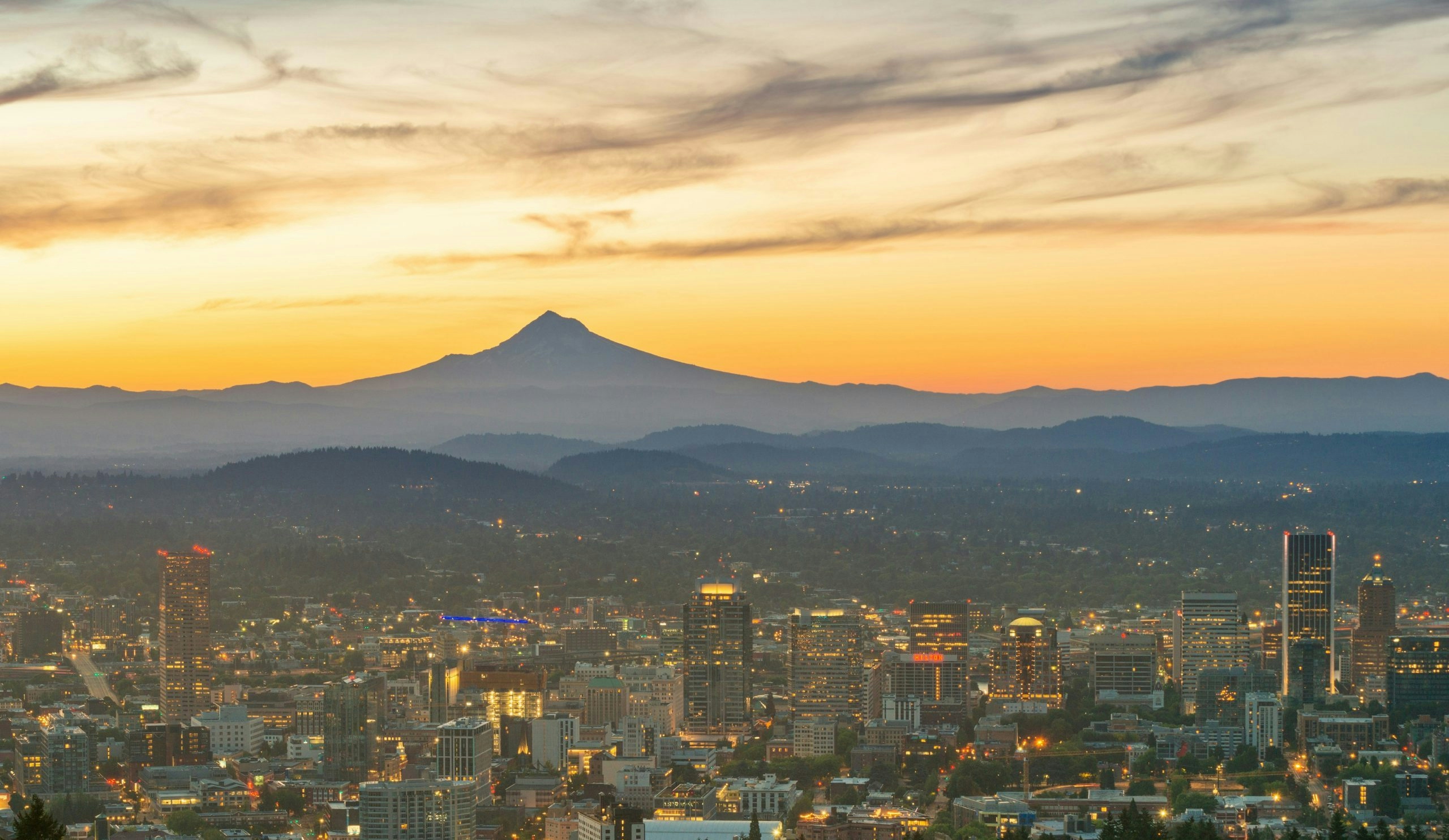 Panoramic view of Portland, Oregon, featuring the Willamette River, downtown skyline, and iconic bridges