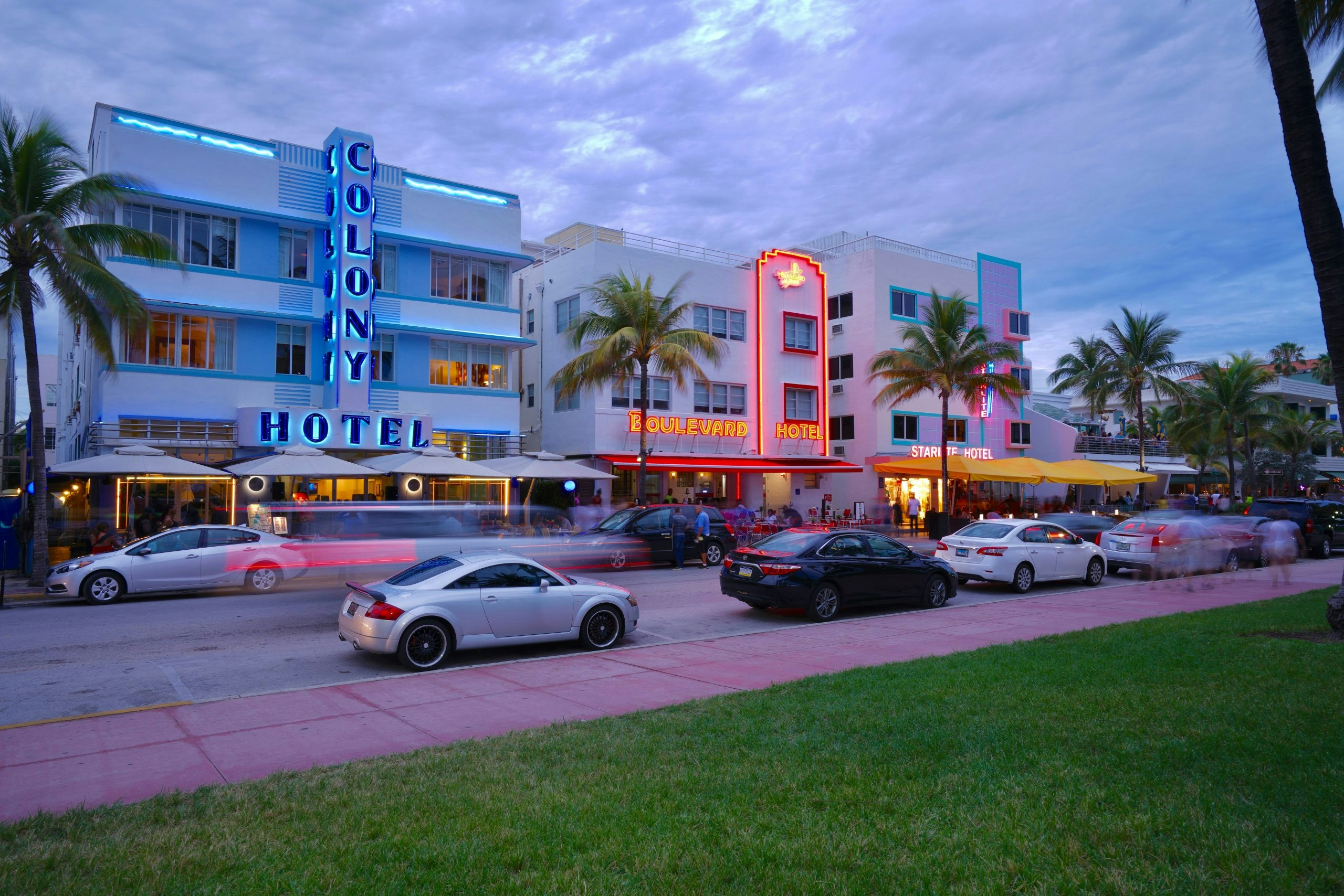 Bustling Ocean Drive featuring restaurants, hotels, and pedestrians