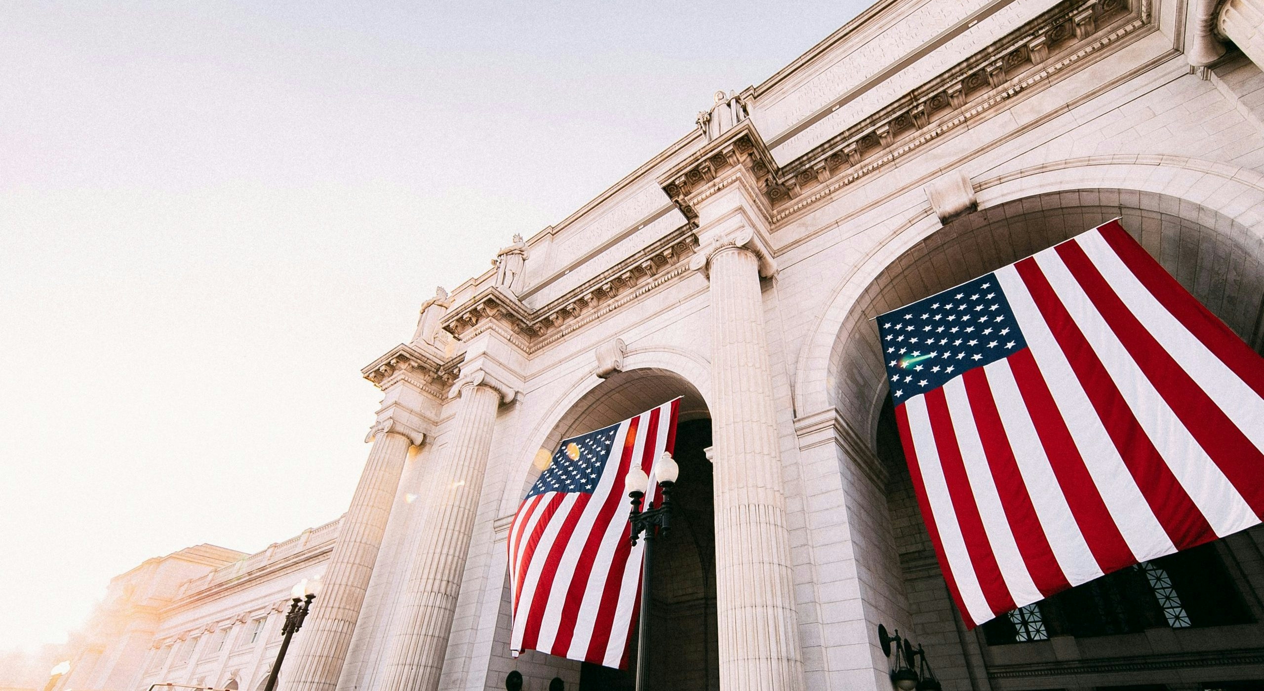 American flag flying beside an iconic monument in Washington, DC