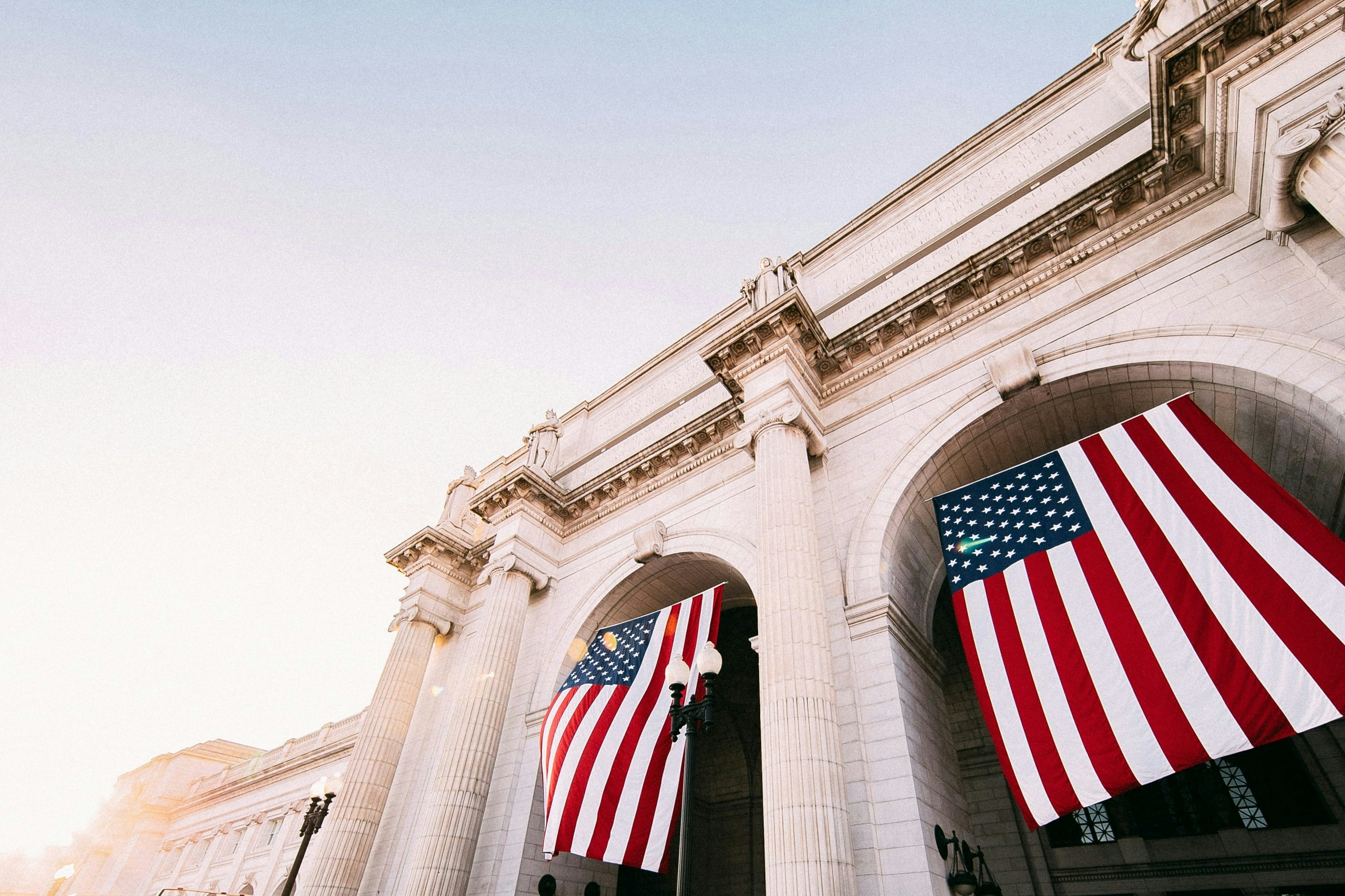 American flag flying beside an iconic monument in Washington, DC