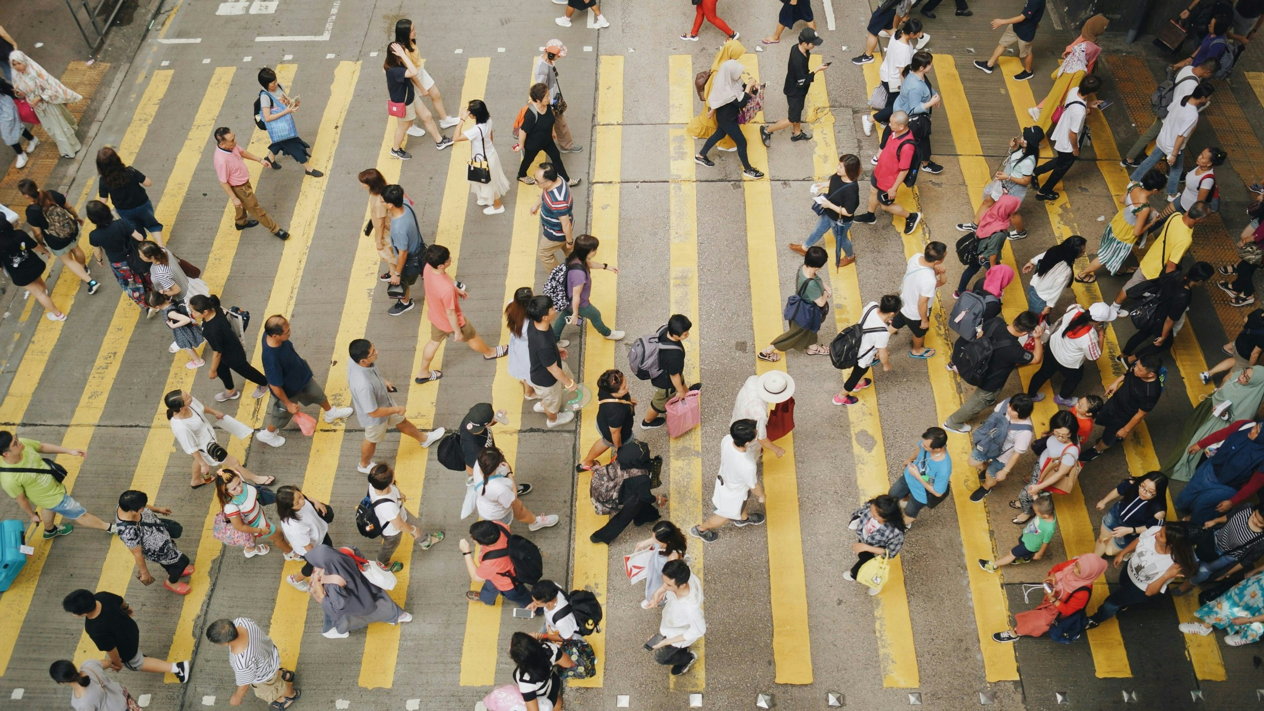 Pedestrians crossing a busy intersection in downtown Hong Kong