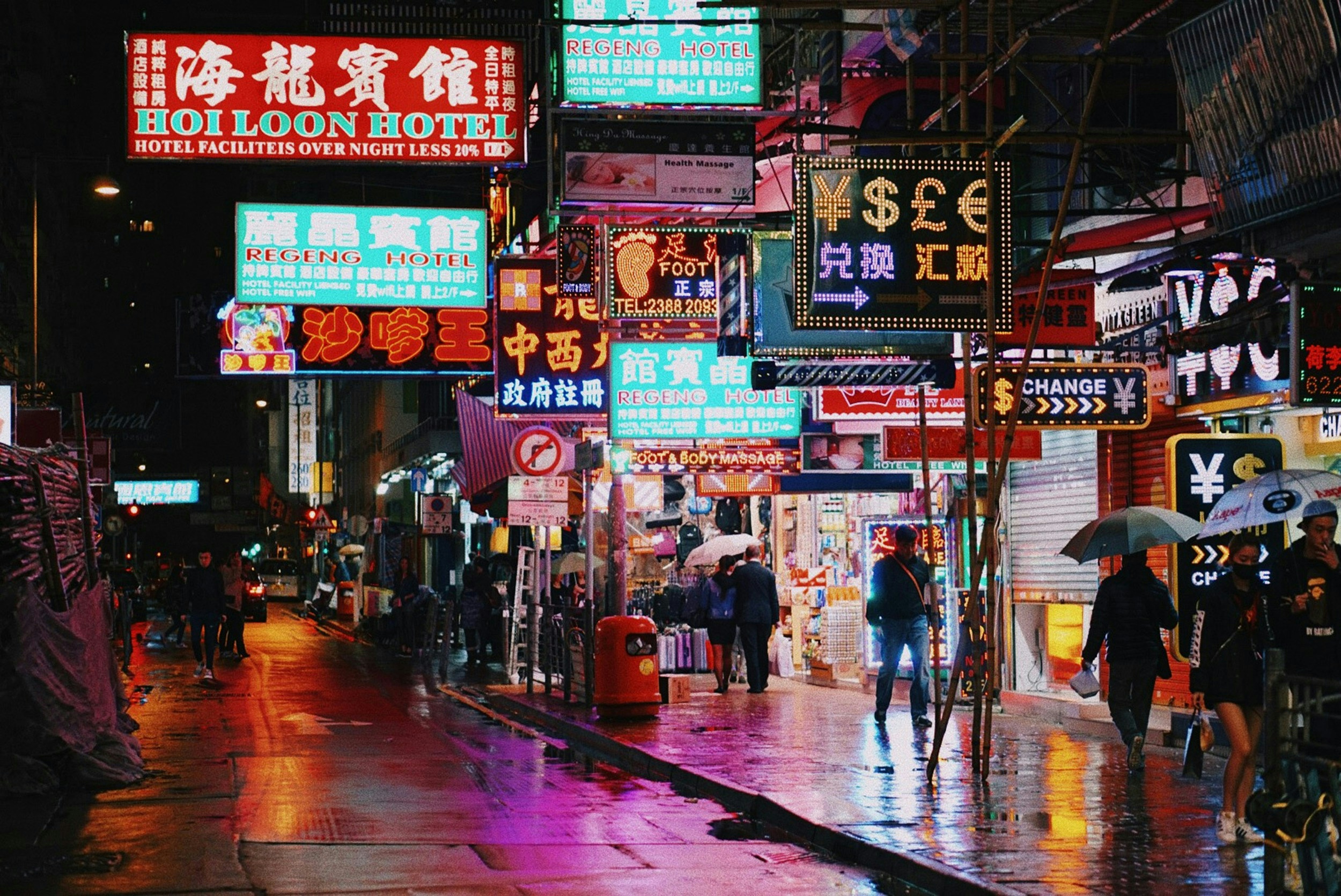 Crowded Hong Kong street featuring shops, restaurants, and city traffic