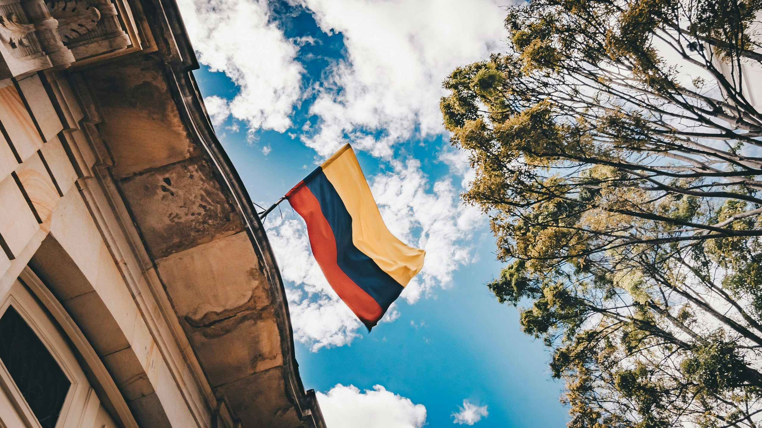 The Colombian flag waving proudly against a clear blue sky.