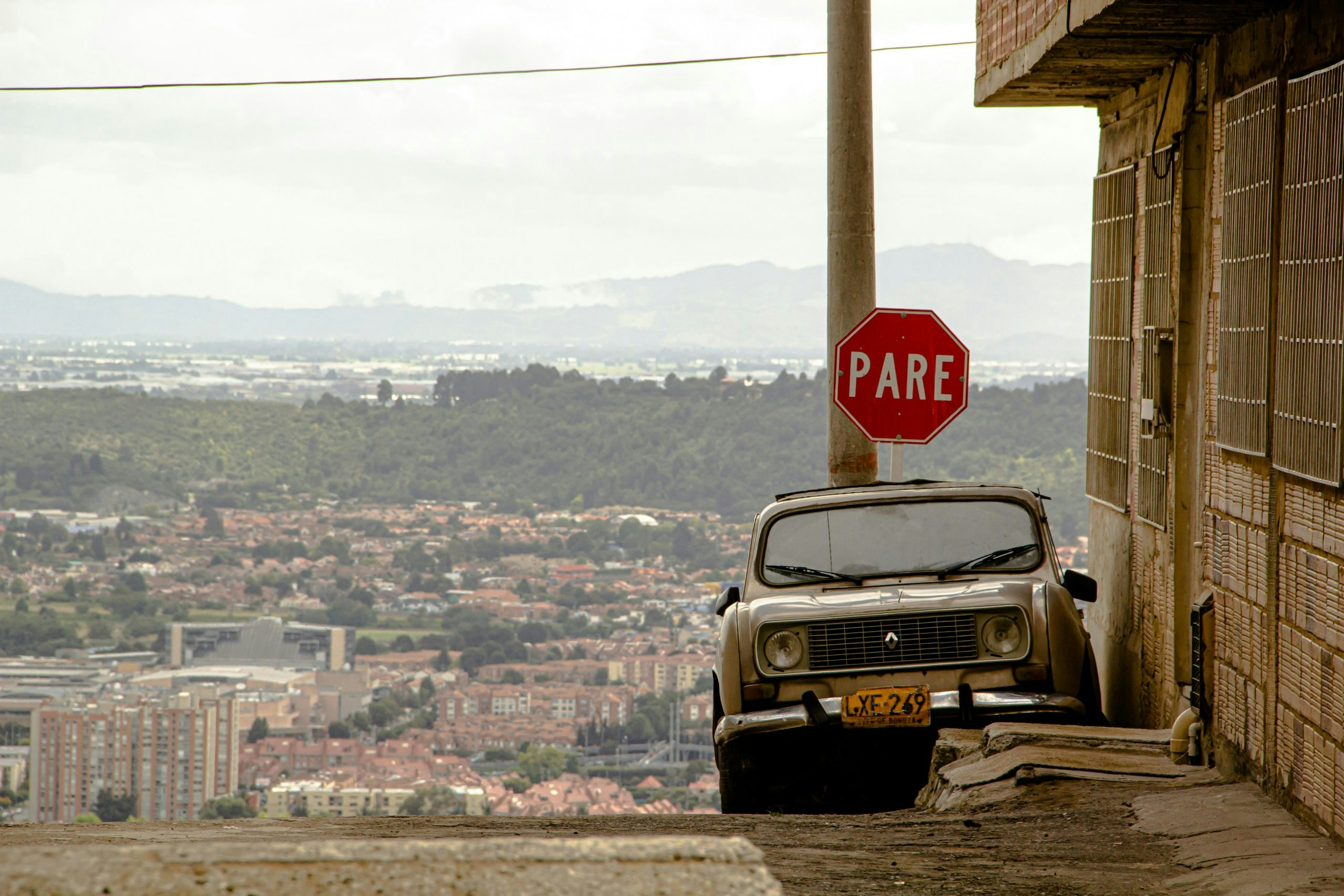 Vintage automobile and a stop sign on a peaceful city street of Bogota