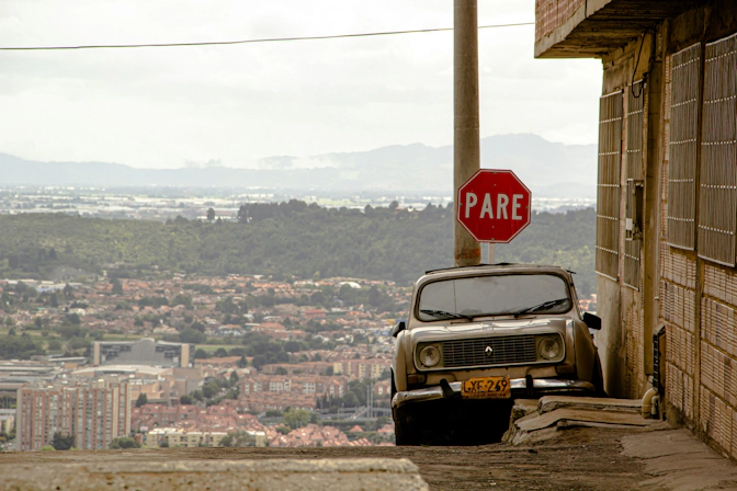 Vintage automobile and a stop sign on a peaceful city street of Bogota