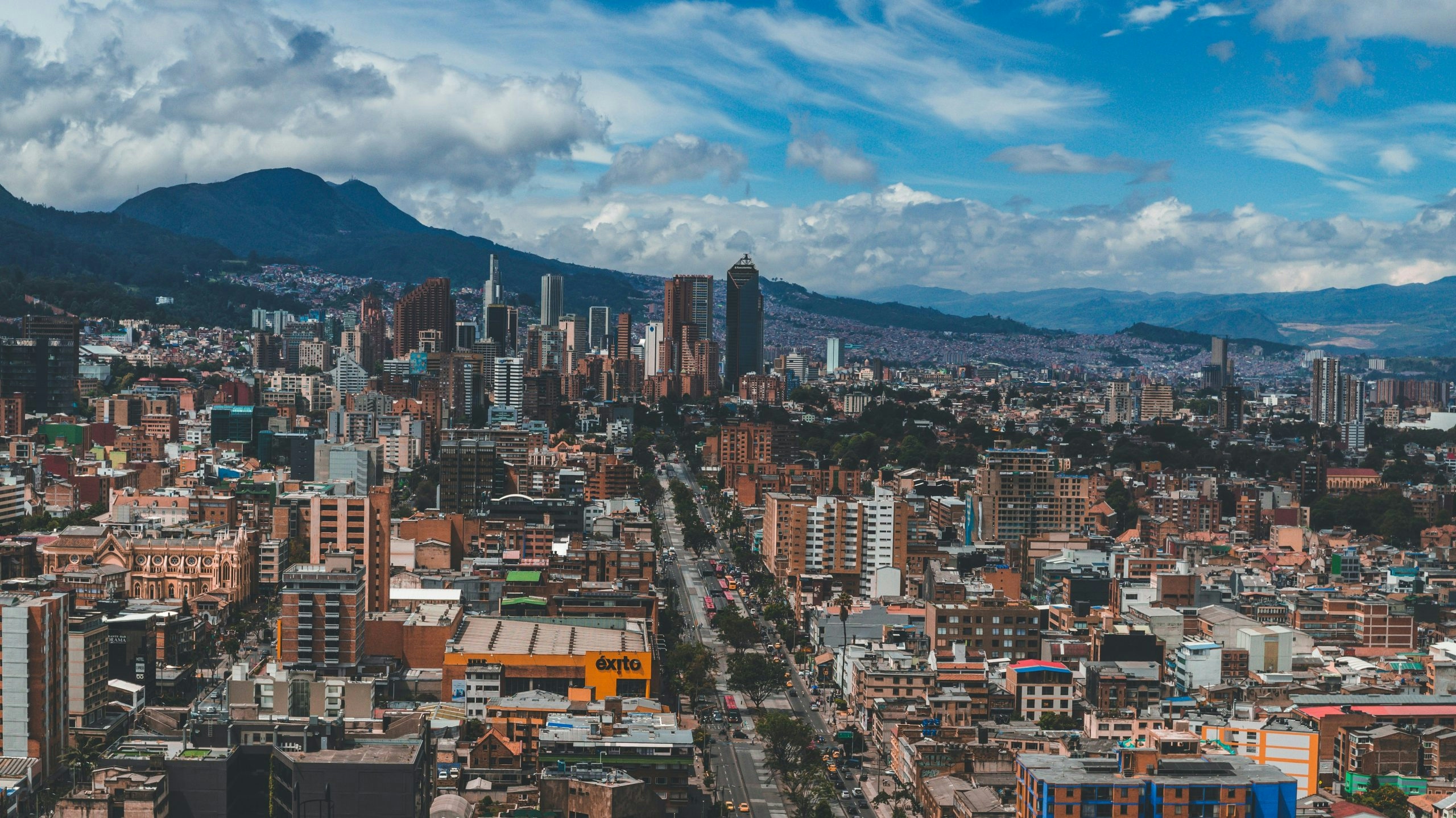 Aerial view of downtown Bogotá featuring modern buildings and surrounding mountains