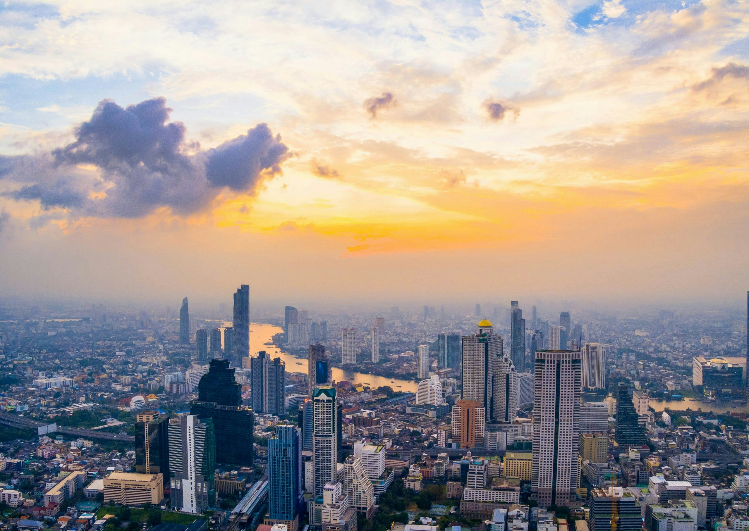 Bangkok skyline at sunset with illuminated skyscrapers and riverfront views