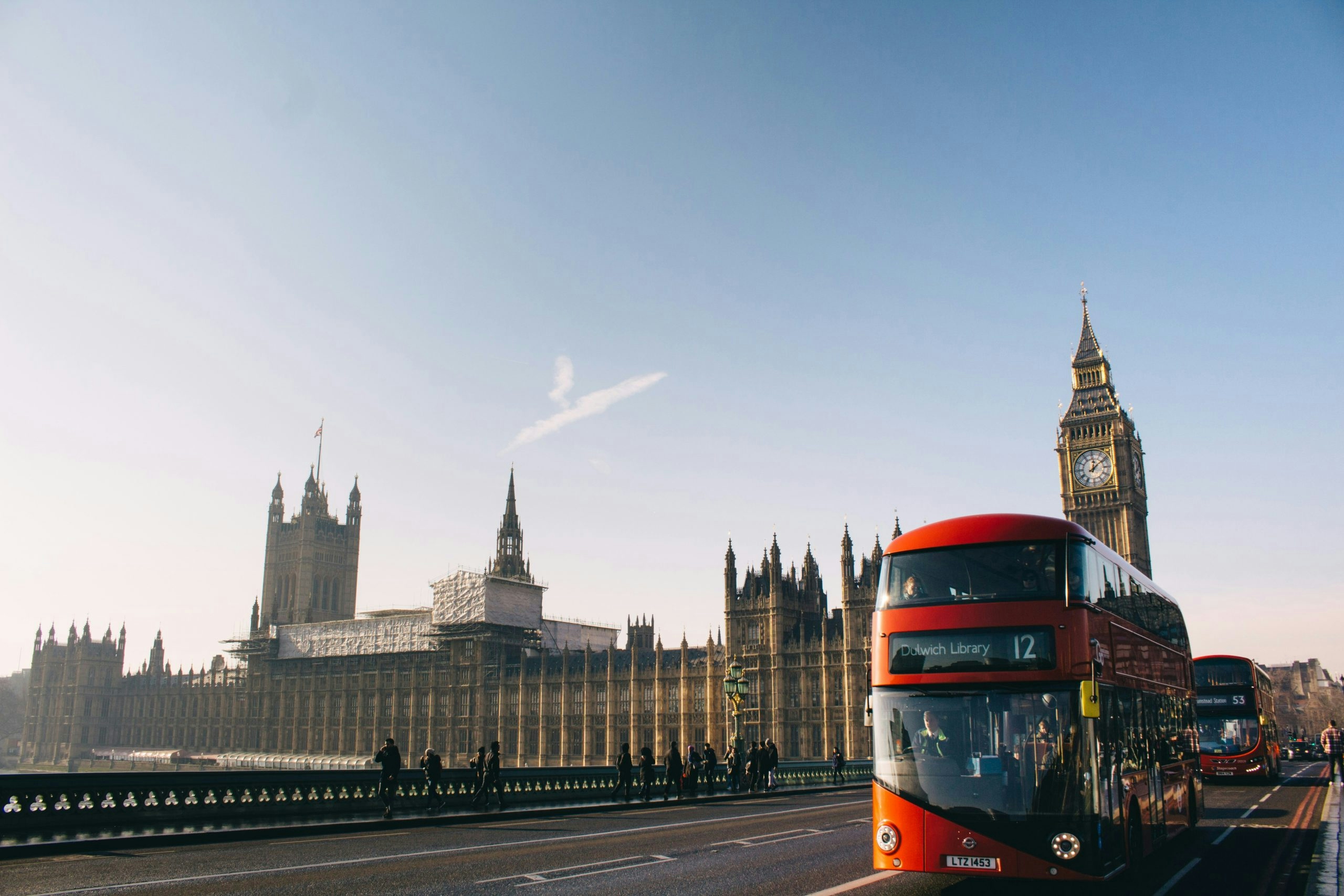 Classic red double-decker bus traveling through the streets of central London