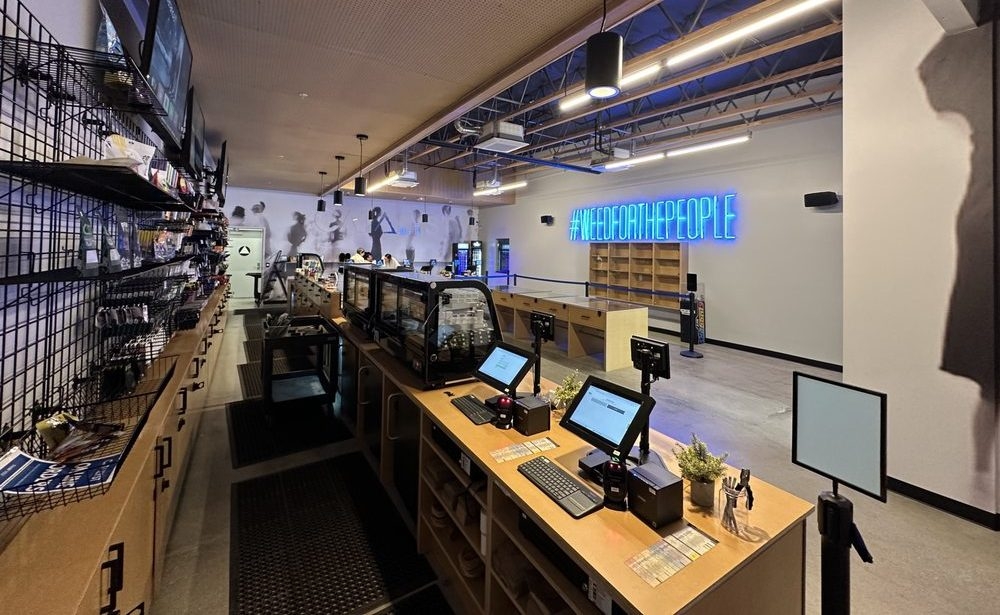 A friendly staff member greeting a customer at the front desk of Catalyst Cannabis dispensary in Antioch, California