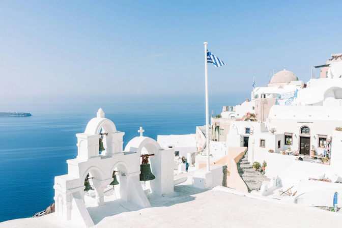 Iconic blue-domed church overlooking the Aegean Sea in Santorini, Greece