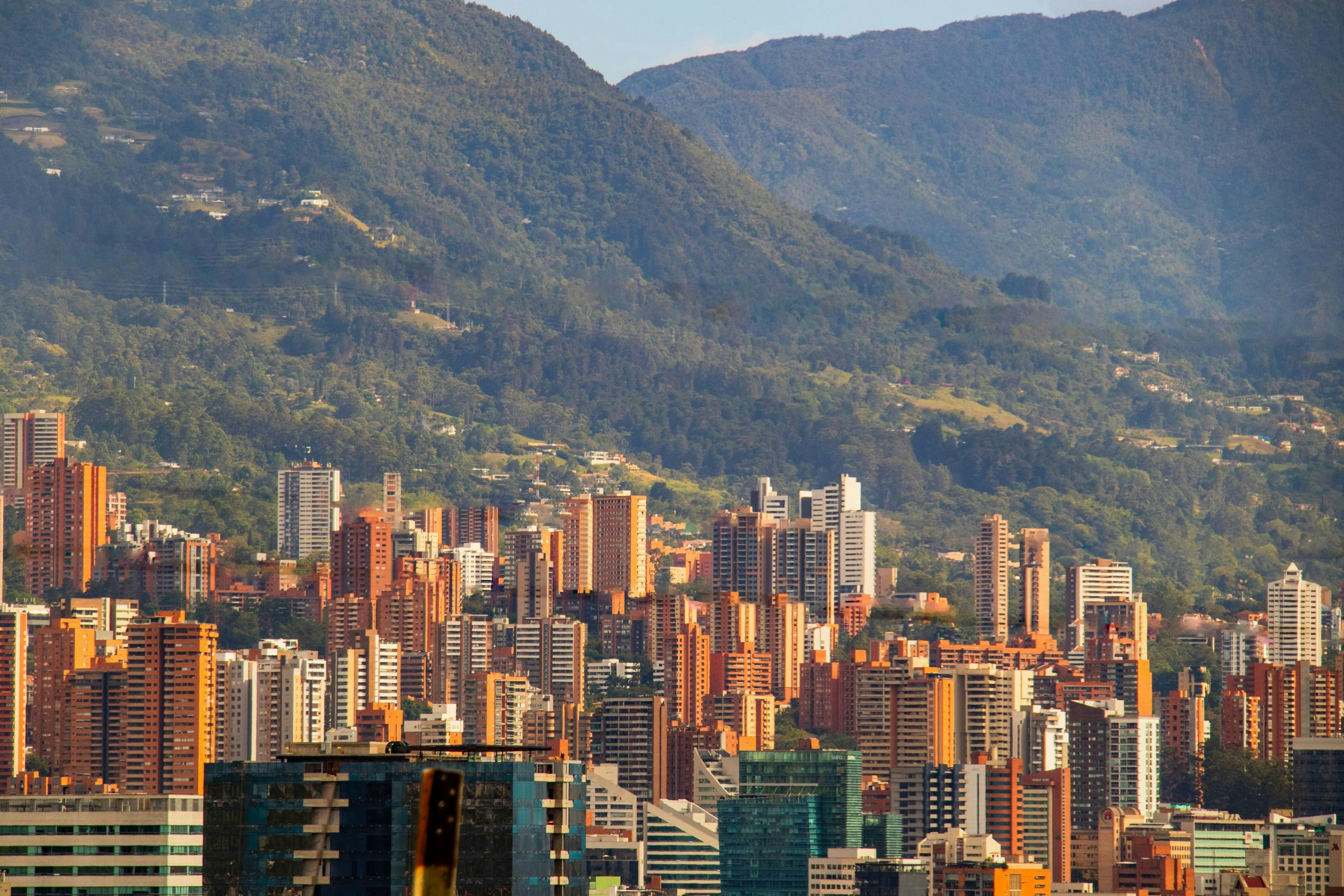 Medellín cityscape featuring modern buildings and lush mountain scenery