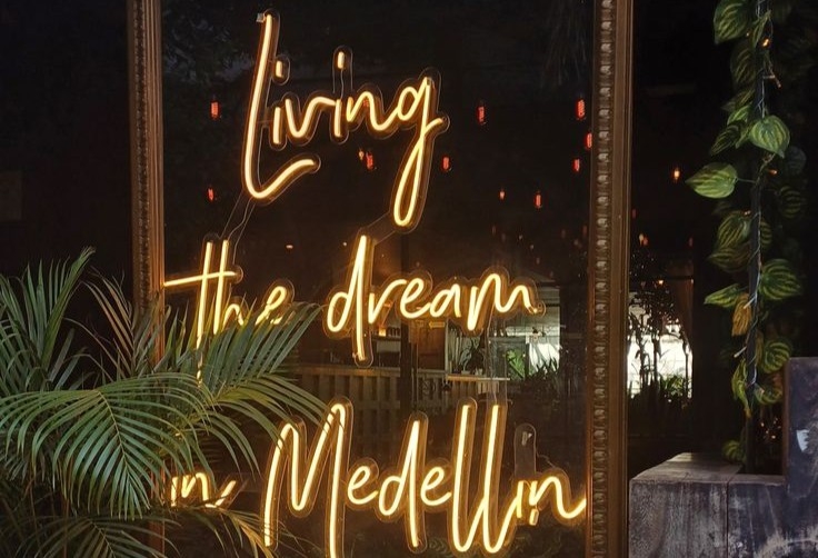 A colorful 'Living the Dream in Medellín' sign displayed at a popular bar in medellin