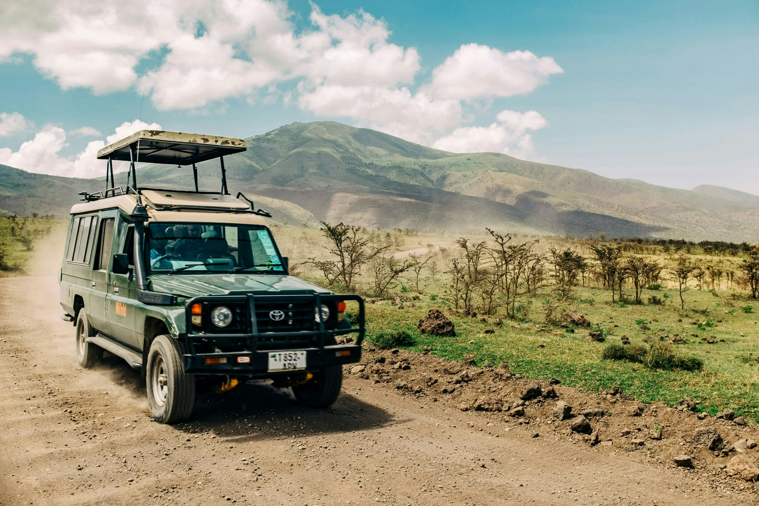 Scenic landscape in Tanzania featuring rolling hills, acacia trees, and open savanna