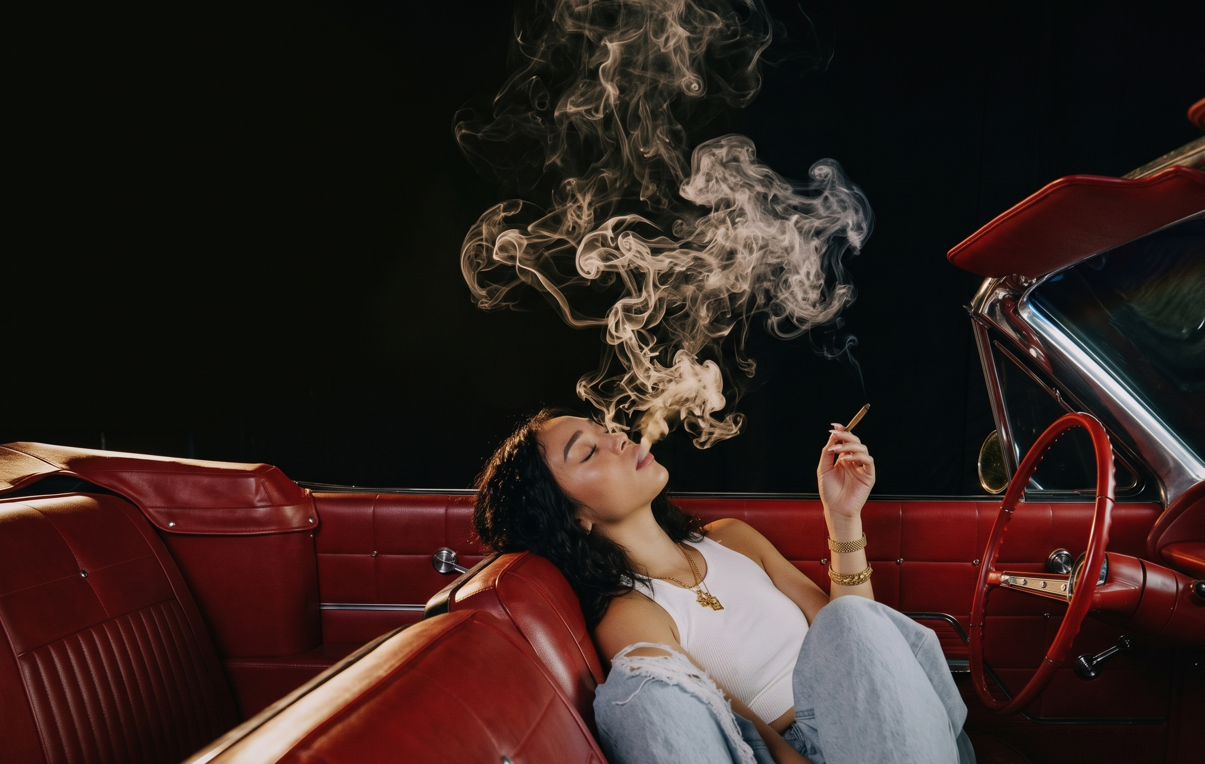 Woman smoking a cannabis joint while sitting in a parked convertible