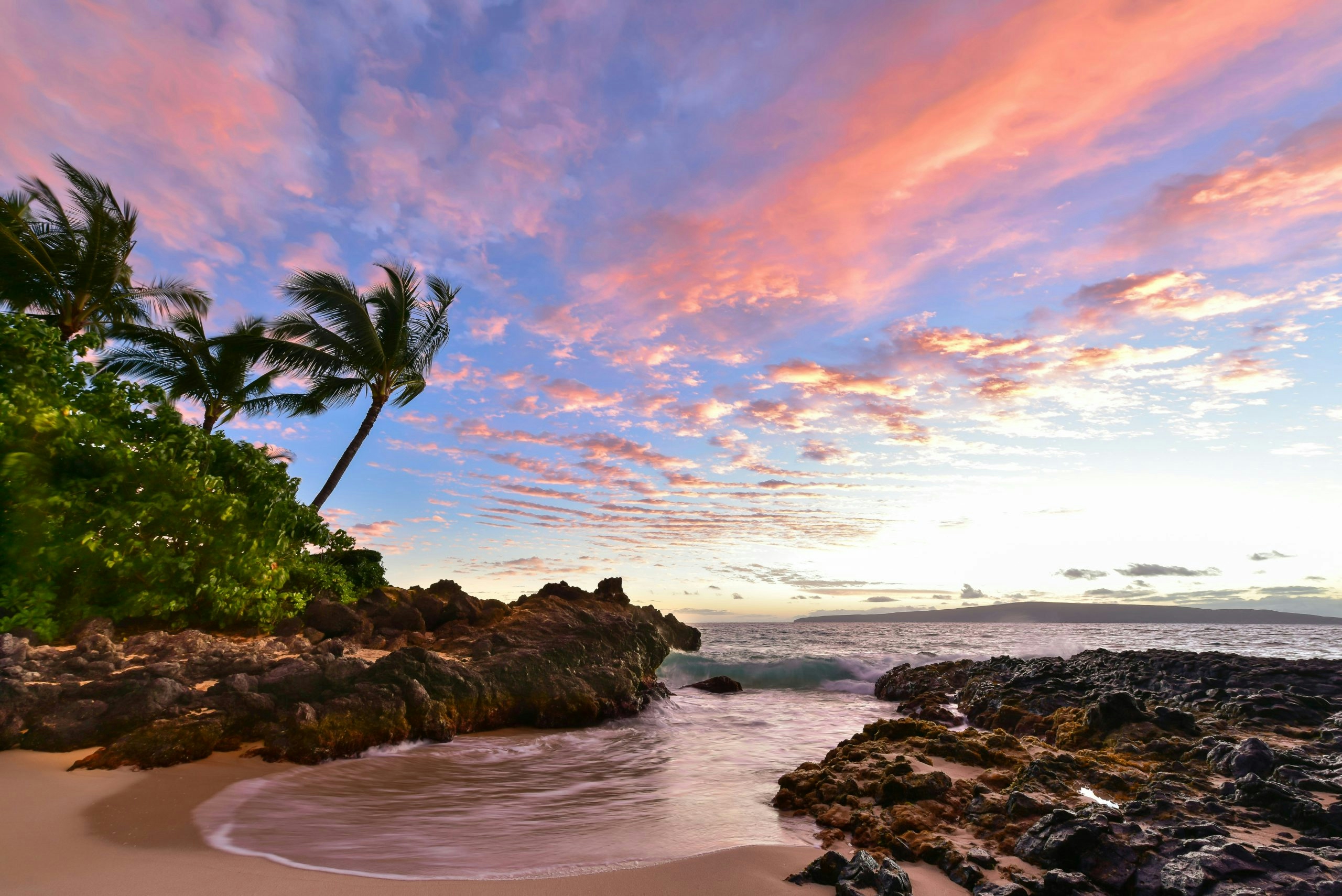 Scenic tropical beach surrounded by lush mountains in Maui