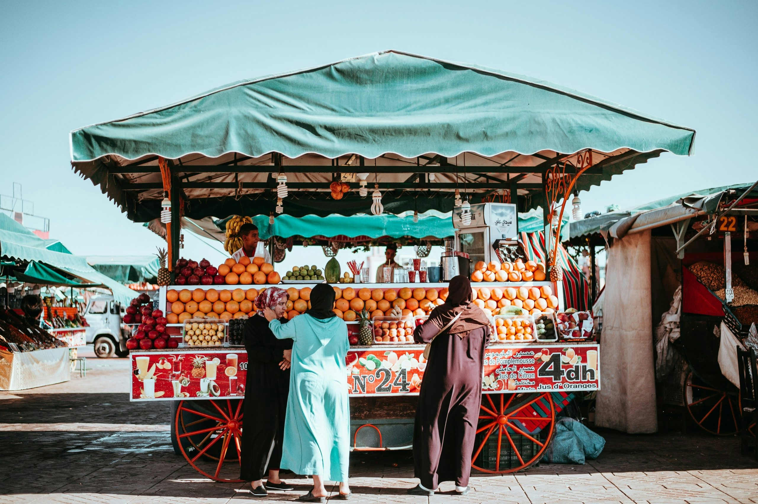 Bustling street market in Marrakech medina with vendors and pedestrians