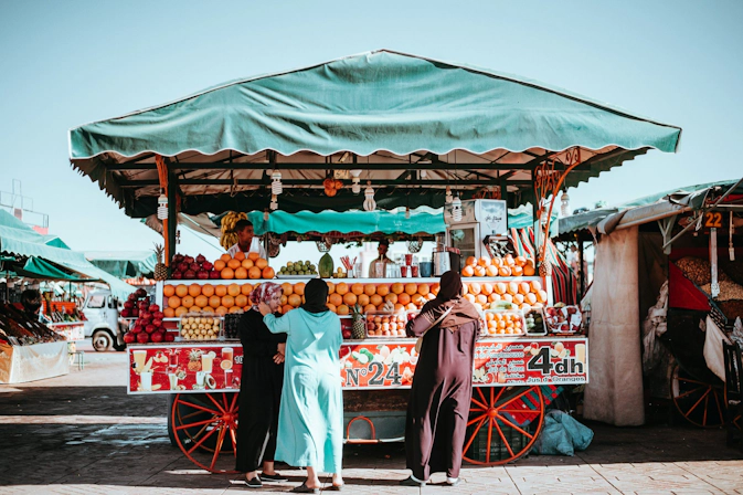 Bustling street market in Marrakech medina with vendors and pedestrians