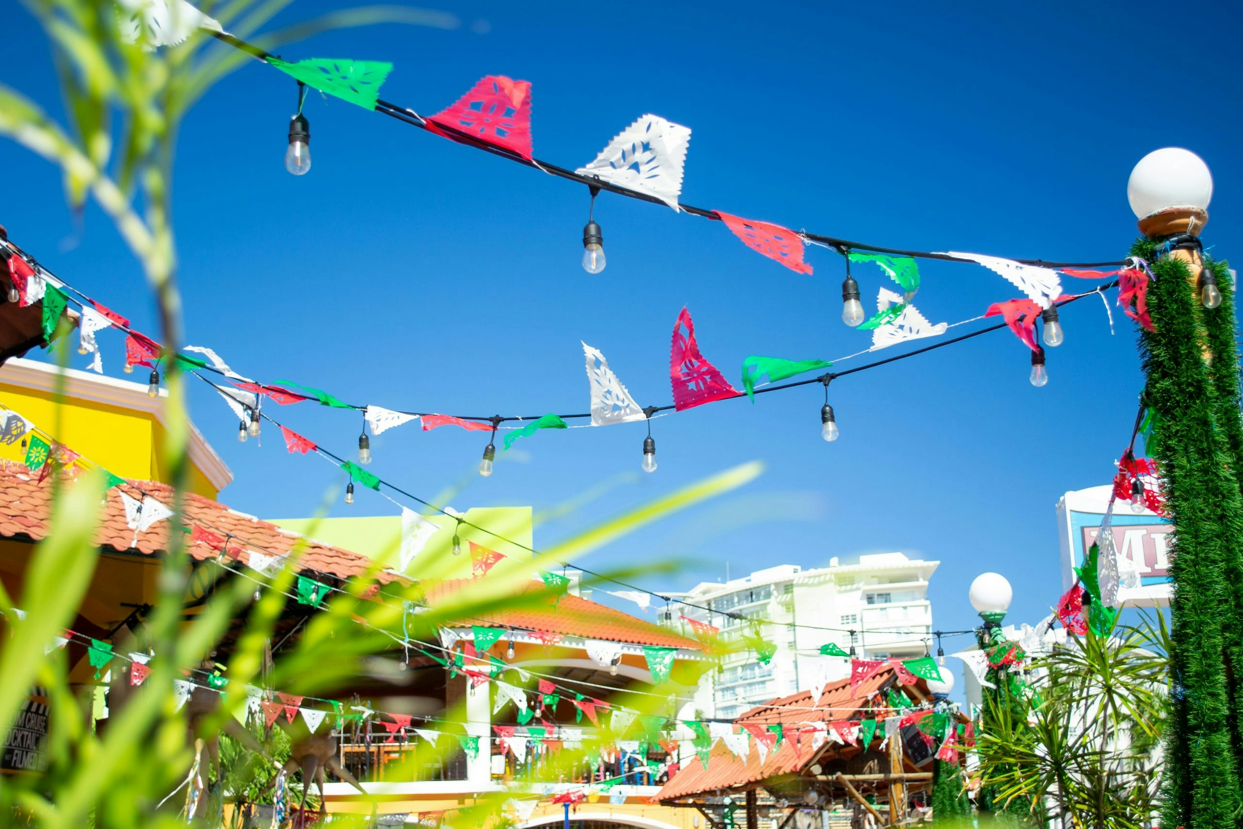 Papel picado banners in Mexican flag colors on a rooftop