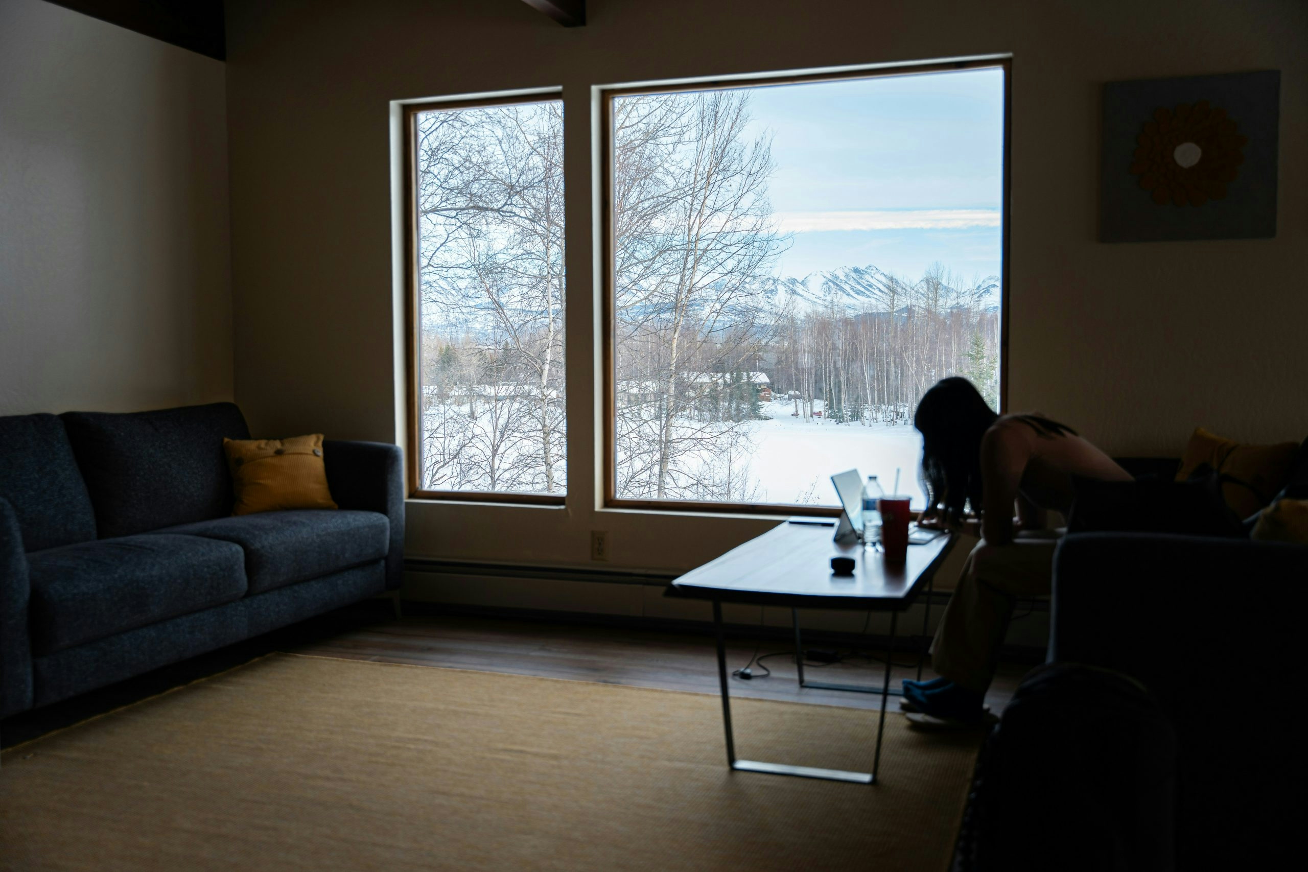 Woman working inside a rustic cabin in Anchorage, Alaska