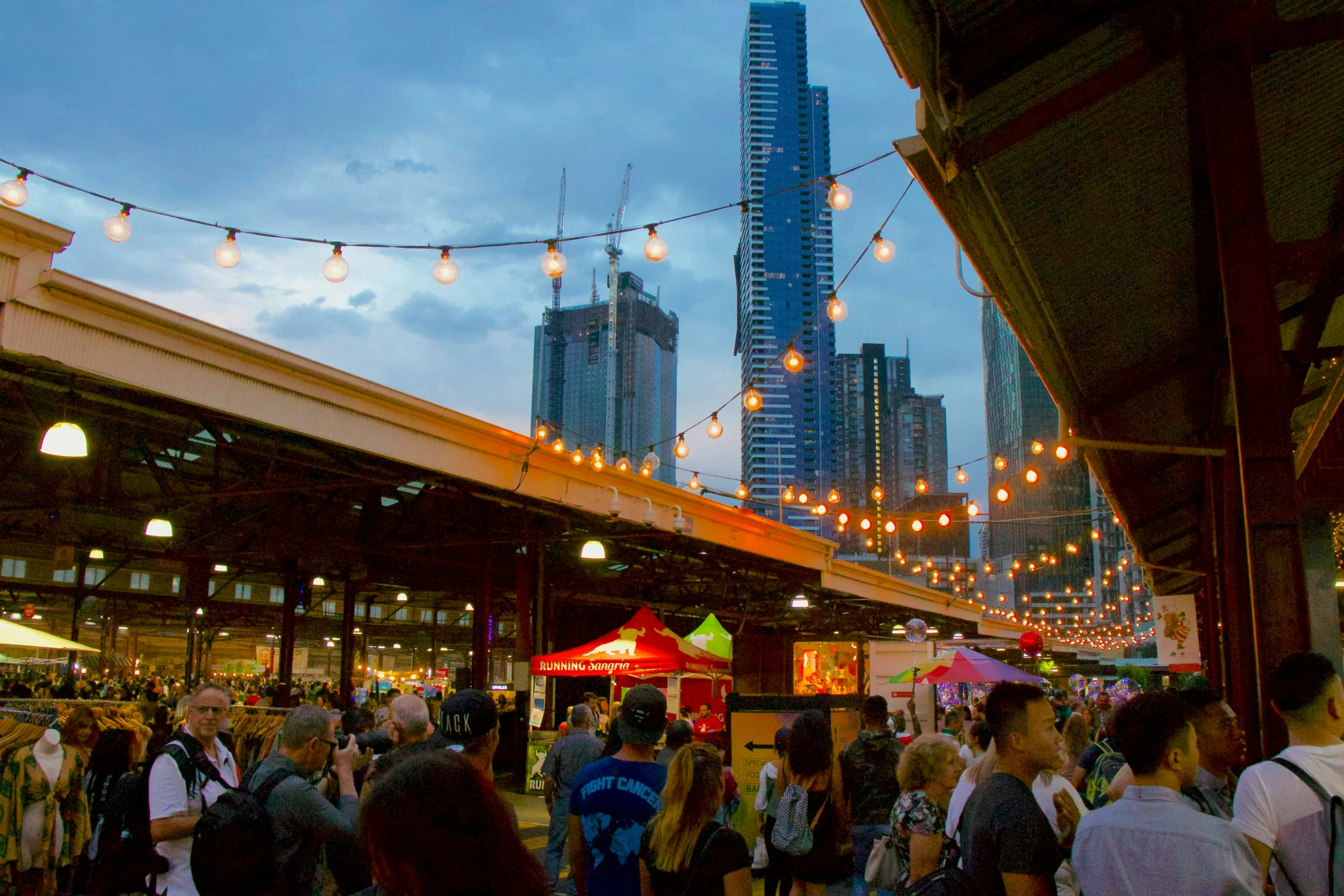 People enjoying drinks and socializing on a street in Melbourne.
