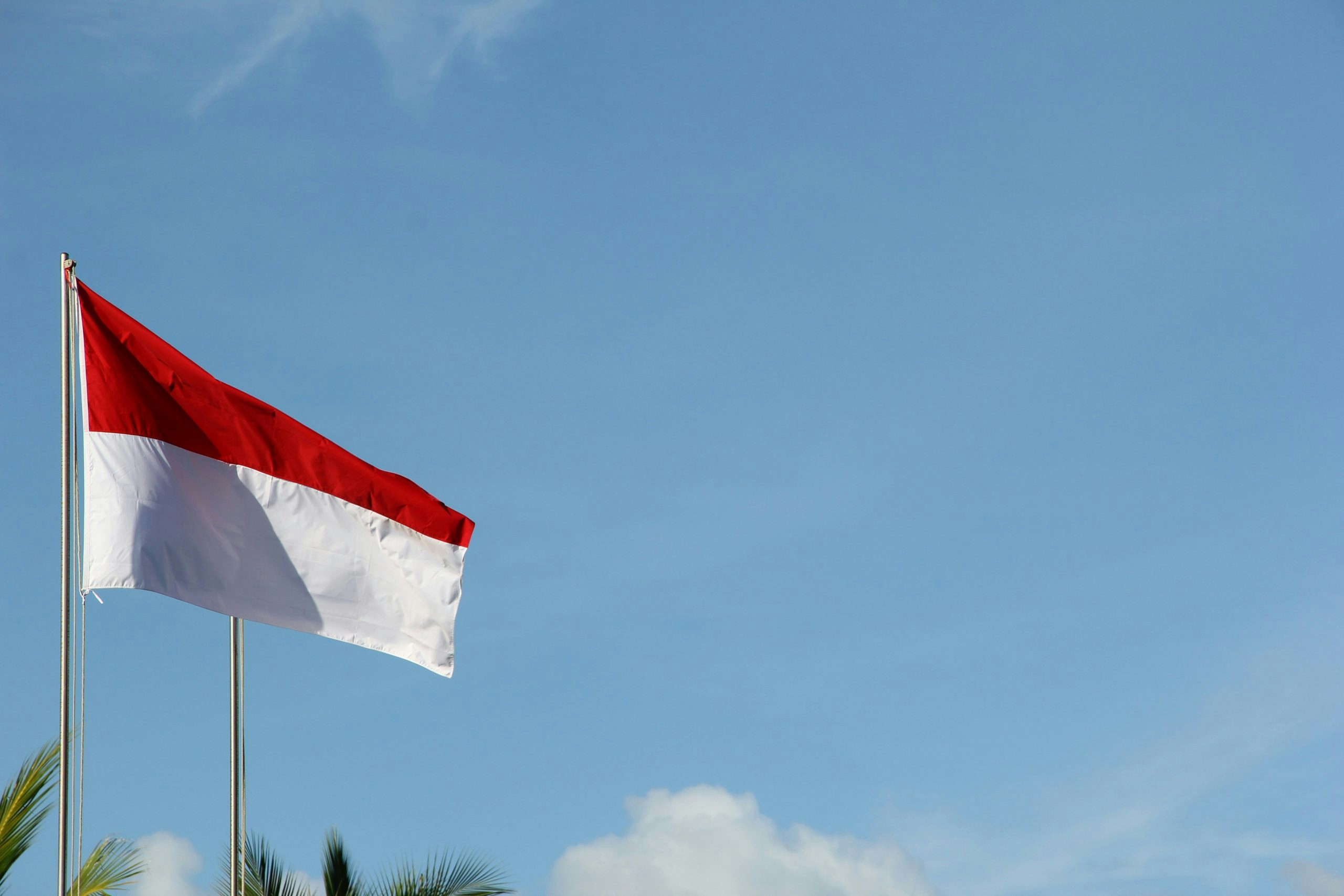 Indonesian flag waving against a clear blue sky