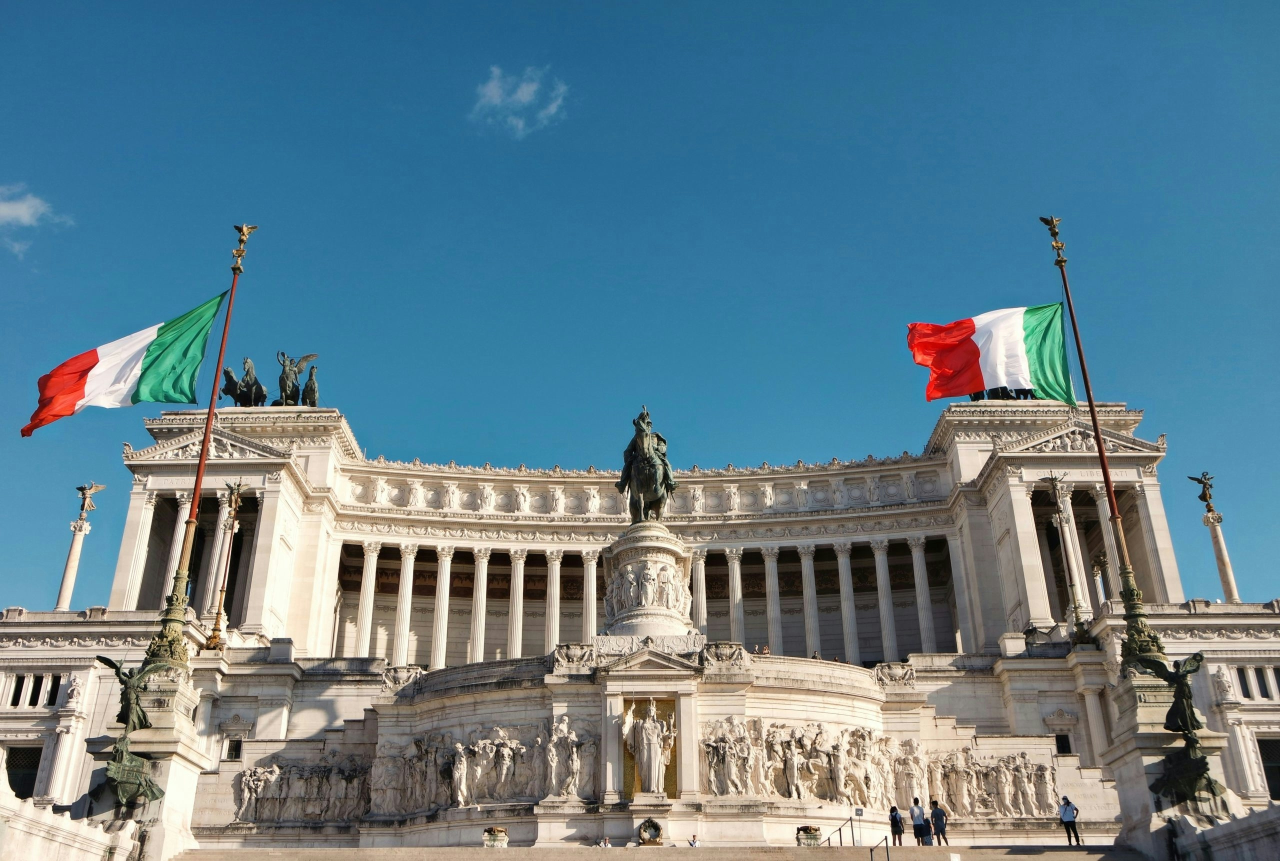 Italian flags displayed around a historic monument in Rome.